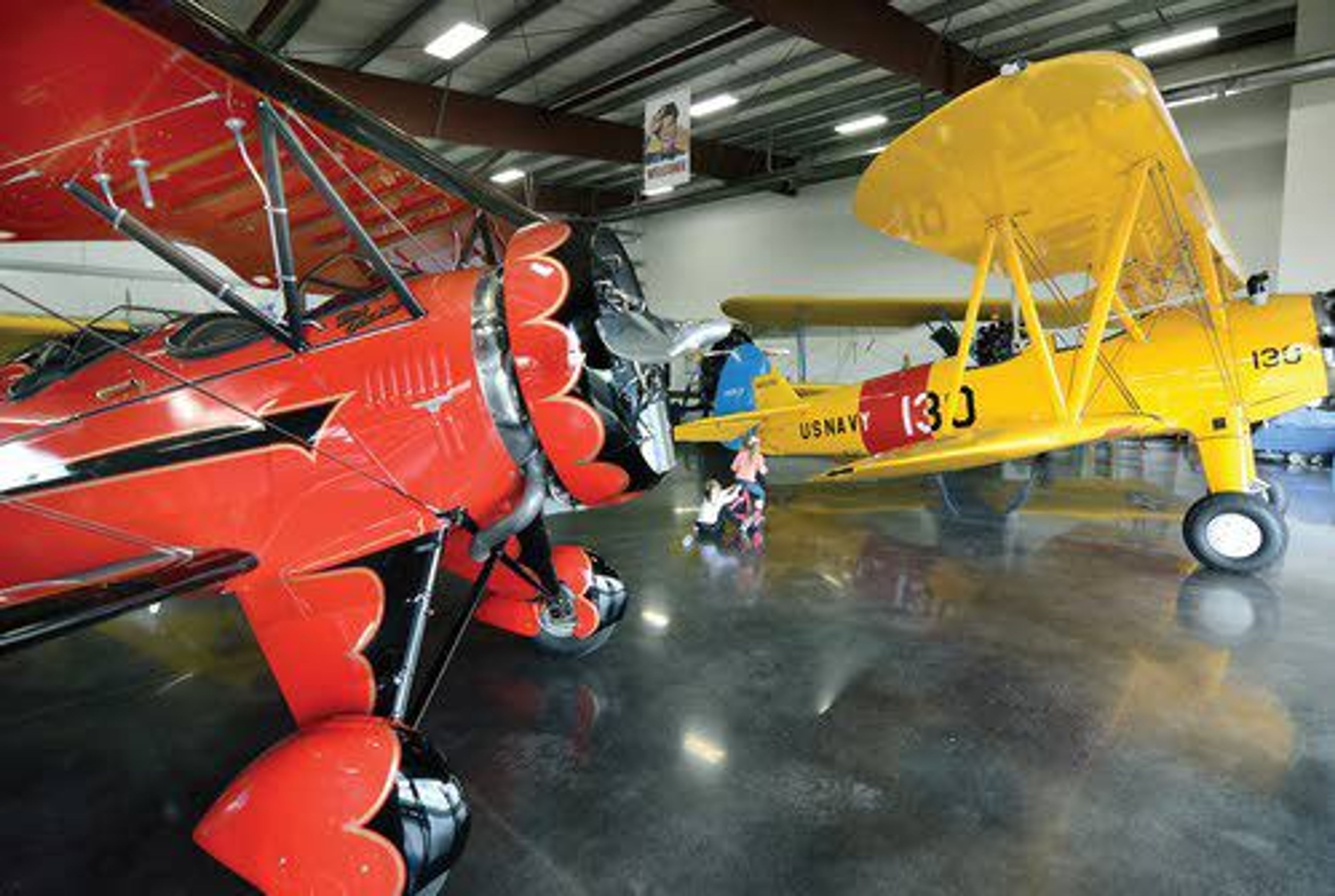 A hangar at the Lewison-Nez Perce County Regional Airport now holds the start of a new aviation musem, a collection of classic Golden Age airplanes like this immaculate red WACO F2 and bright yellow Boeing-Stearman Navy trainer.