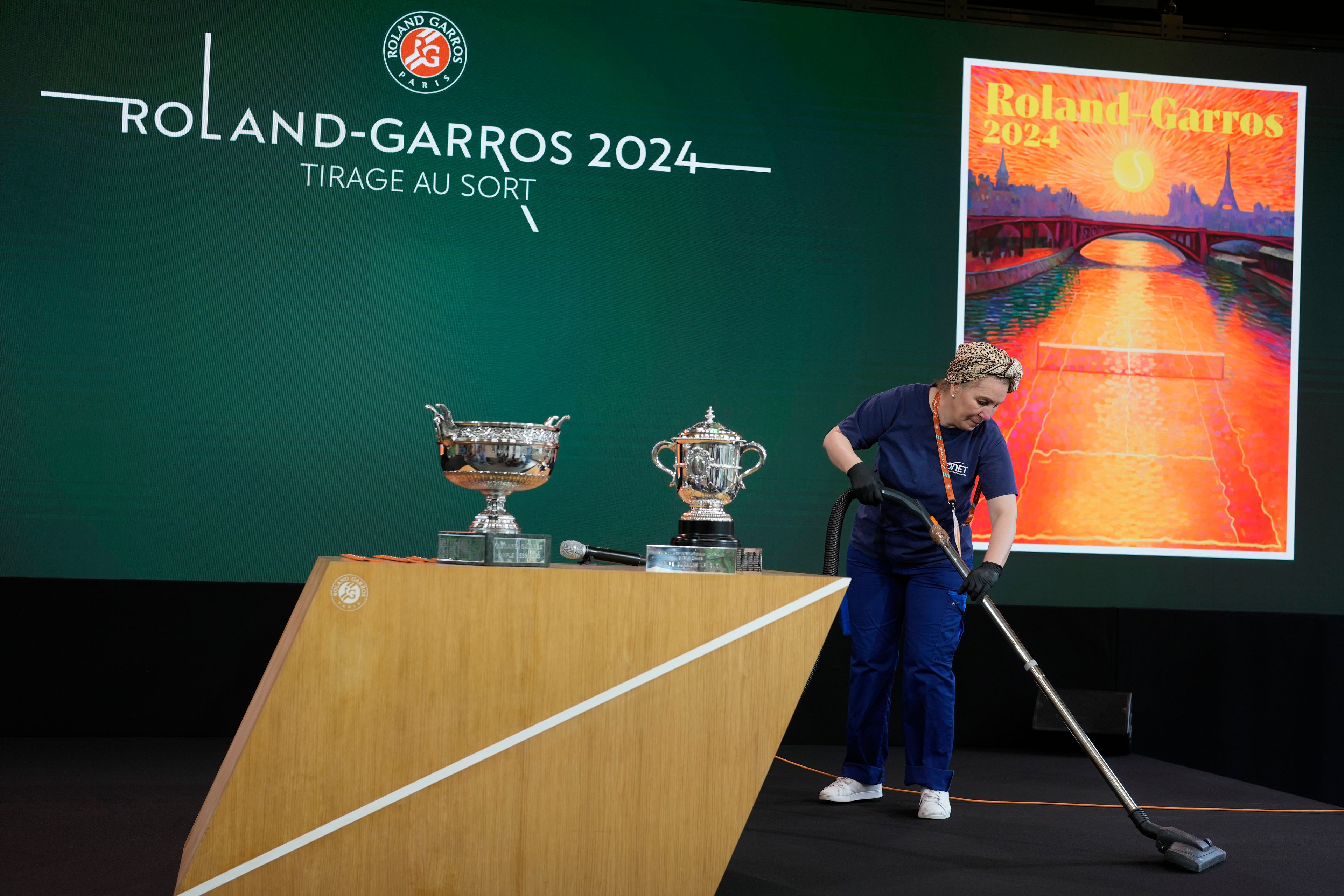 A woman cleans the stage before the draw for the French Tennis Open at the Roland Garros stadium, Thursday, May 23, 2024 in Paris. The tournament starts Sunday May 26, 2024.