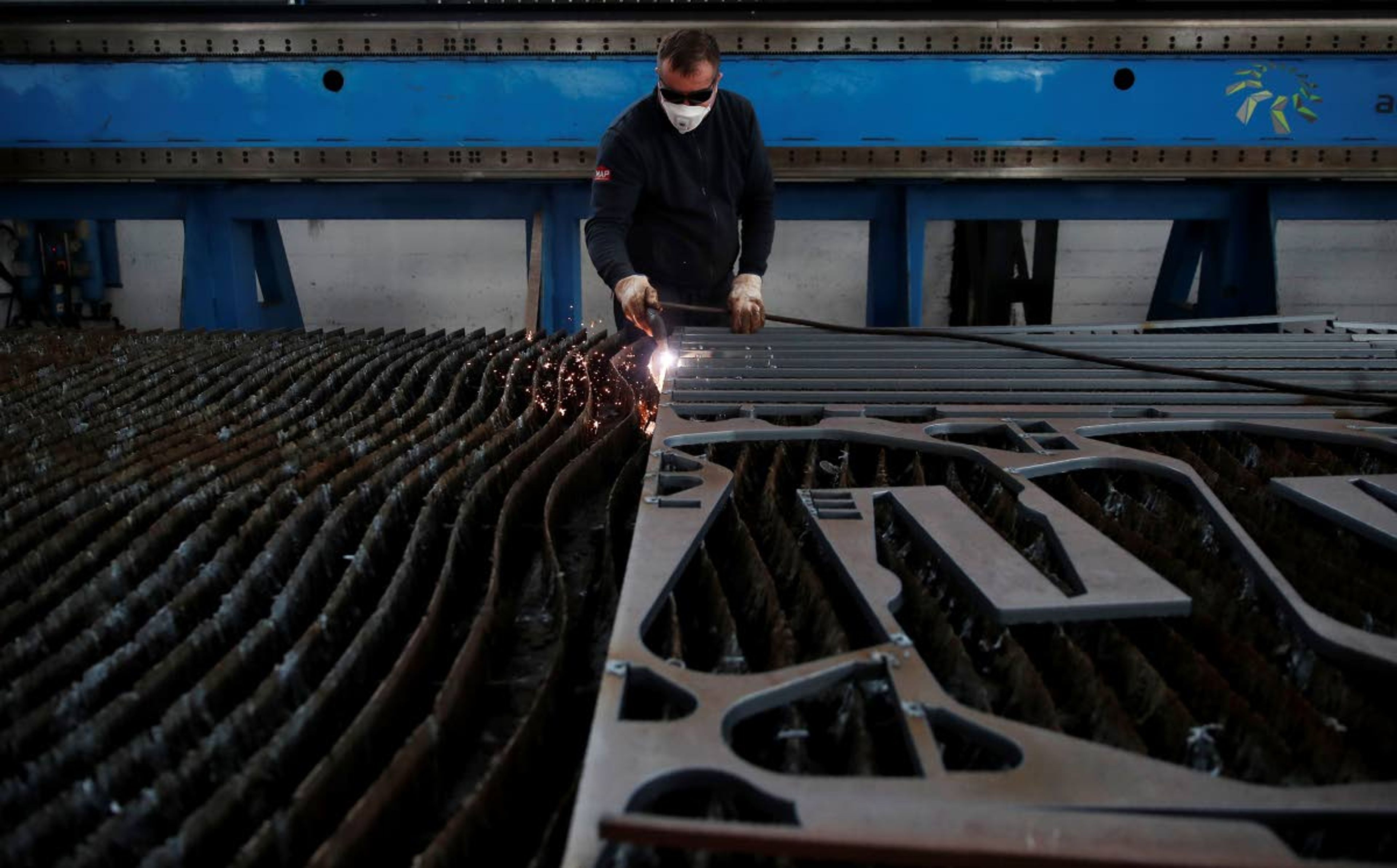 A man works at MAP, a factory operating in design, manufacture and installation of steel structures for civil and industrial use, in Corsico, near Milan, Italy, Wednesday, May 6, 2020. Italy began stirring again after the coronavirus shutdown, with 4.4 million Italians able to return to work and restrictions on movement eased in the first European country to lock down in a bid to stem COVID-19 infections. (AP Photo/Antonio Calanni)