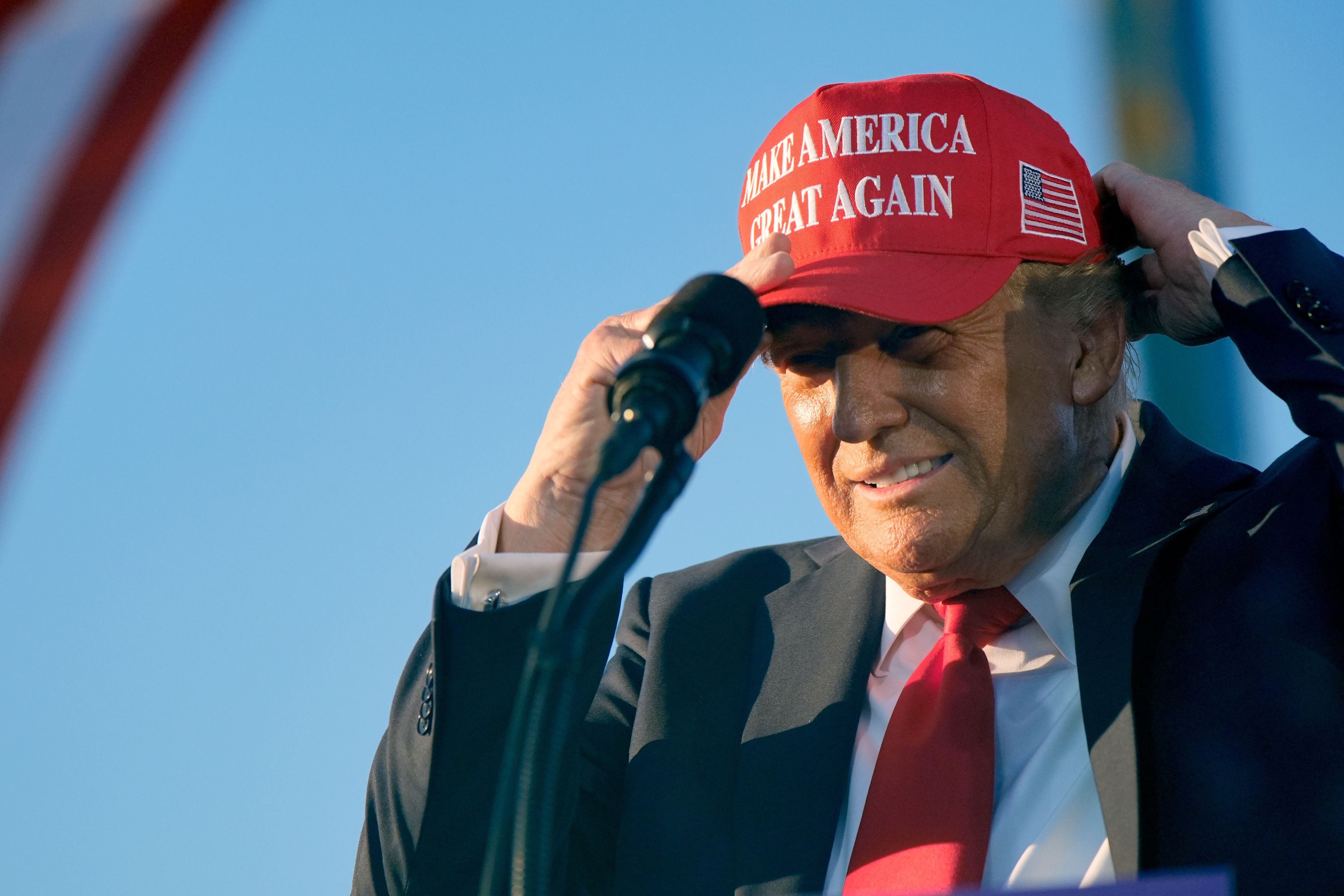 Republican presidential nominee former President Donald Trump puts on a campaign hat as he speaks at a campaign rally at the Calhoun Ranch, Saturday, Oct. 12, 2024, in Coachella, Calif. (AP Photo/Alex Brandon)