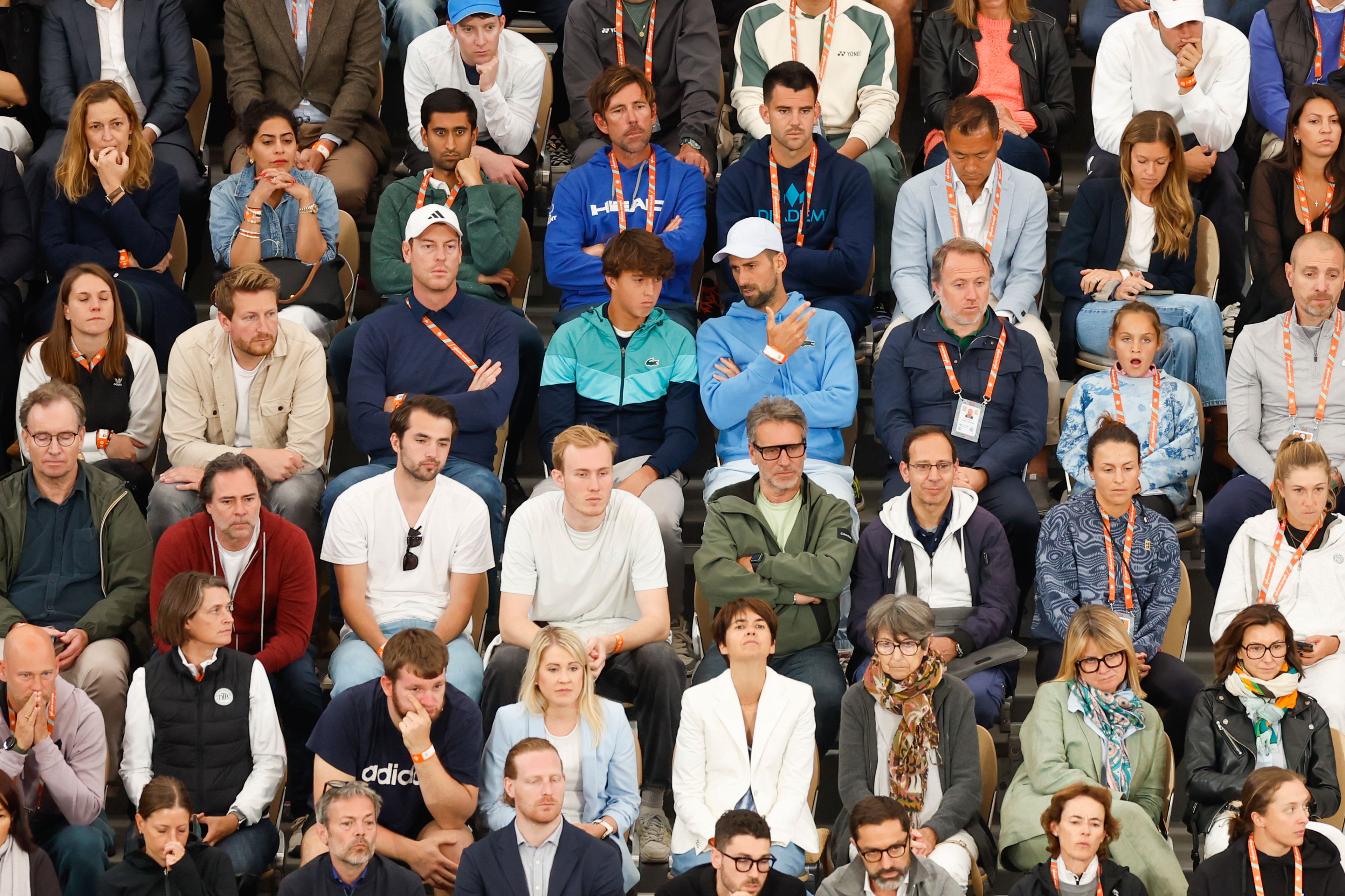 Serbia's Novak Djokovic, center right with blue sweater and white cap, watches Spain's Rafael Nadal's first round match of the French Open tennis tournament against Germany's Alexander Zverev at the Roland Garros stadium in Paris, Monday, May 27, 2024.