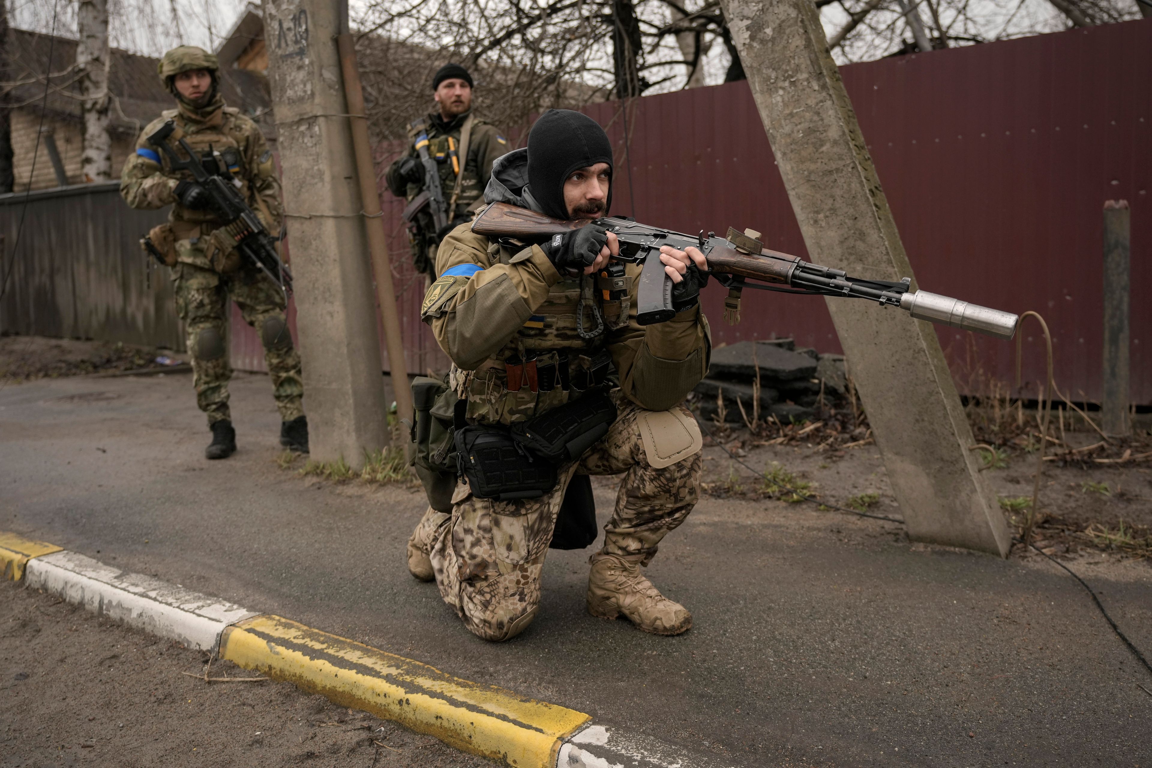 A Ukrainian serviceman secures the retreat of fellow soldiers who checked bodies lying on the street for booby traps in the formerly Russian-occupied Kyiv suburb of Bucha, Ukraine, Saturday, April 2, 2022. As Russian forces pull back from Ukraine's capital region, retreating troops are creating a "catastrophic" situation for civilians by leaving mines around homes, abandoned equipment and "even the bodies of those killed," President Volodymyr Zelenskyy warned Saturday.(AP Photo/Vadim Ghirda)