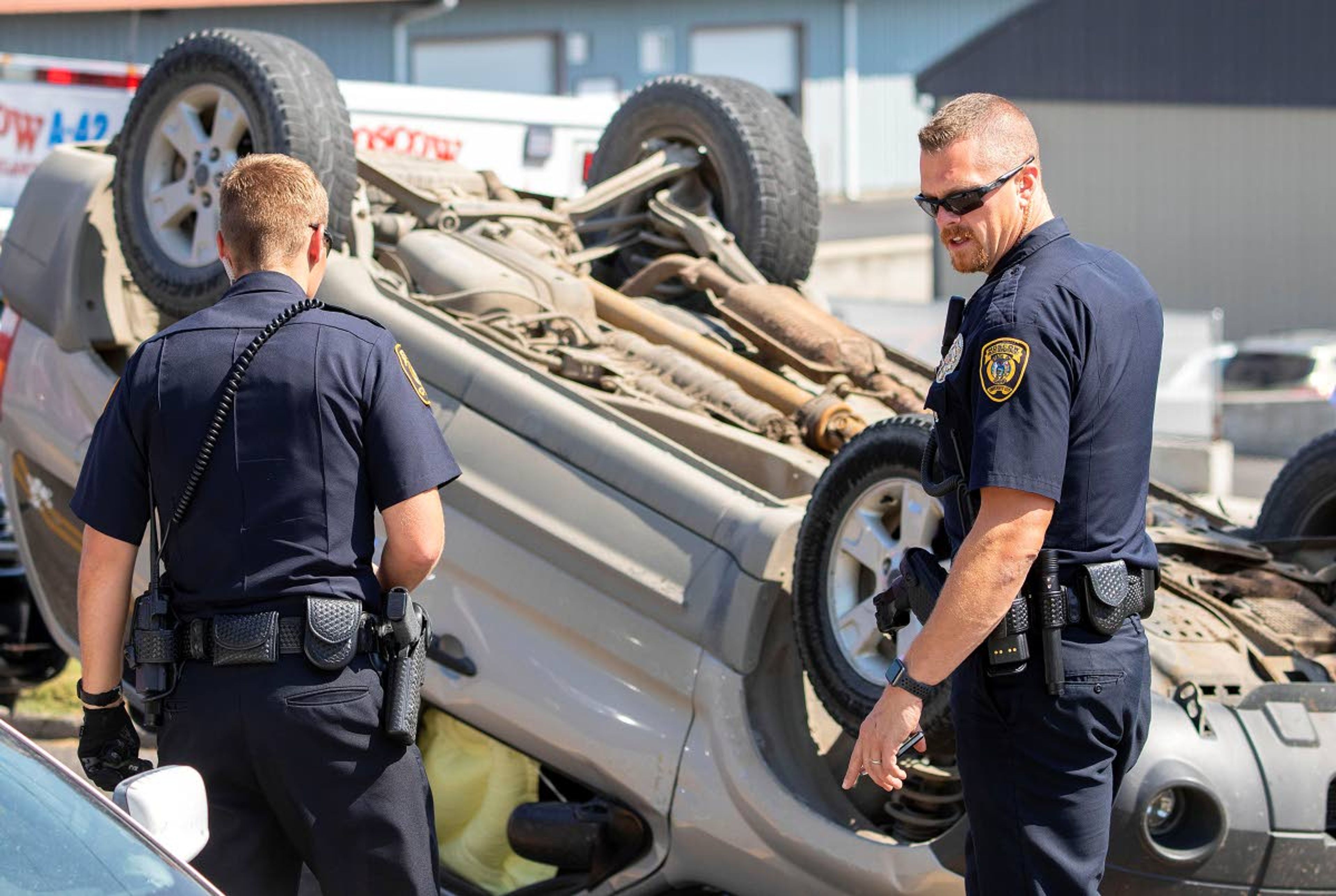 Moscow police officers talk at the scene of a rollover crash Tuesday at the intersection of A and Line streets in Moscow.