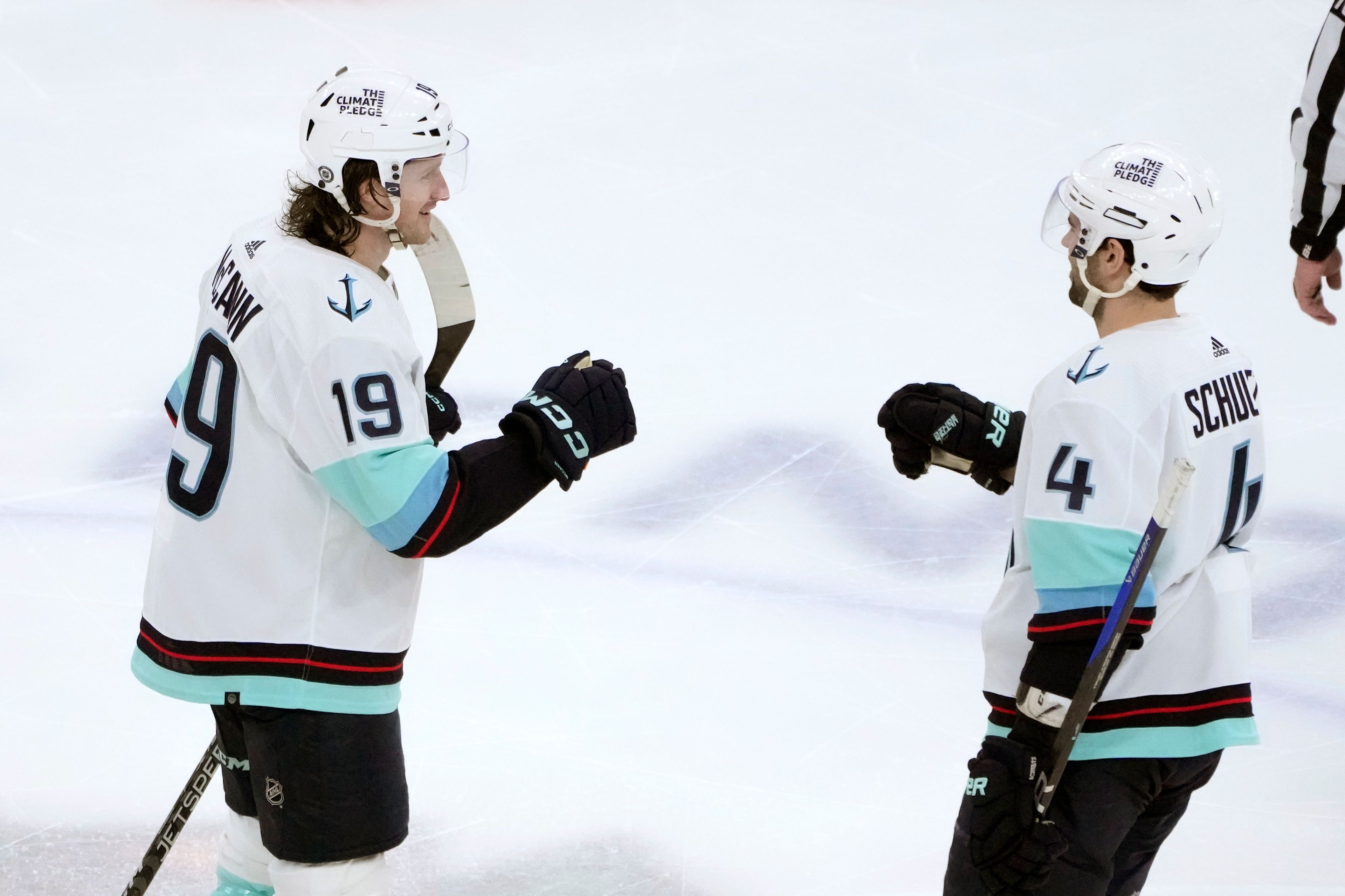 Seattle Kraken's Jared McCann (19) celebrates his hat trick with Justin Schultz during the third period of the team's NHL hockey game against the Chicago Blackhawks on Saturday, Jan. 14, 2023, in Chicago. (AP Photo/Charles Rex Arbogast)