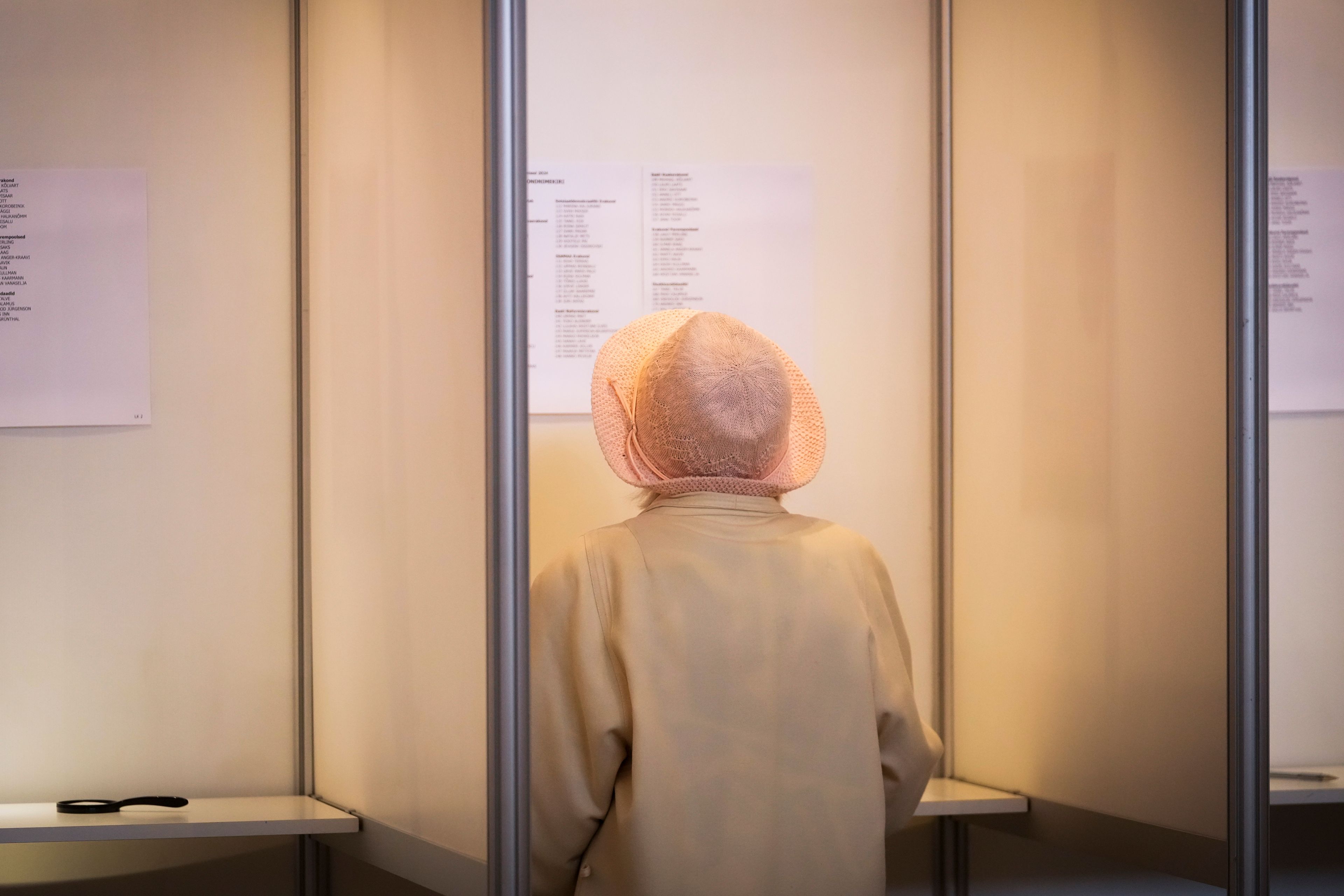 A woman reads the list with the names of the candidate before voting, during the European Parliament election in Tallinn, Estonia, Sunday, June 9, 2024. Polling stations opened across Europe on Sunday as voters from 20 countries cast ballots in elections that are expected to shift the European Union's parliament to the right and could reshape the future direction of the world's biggest trading bloc.