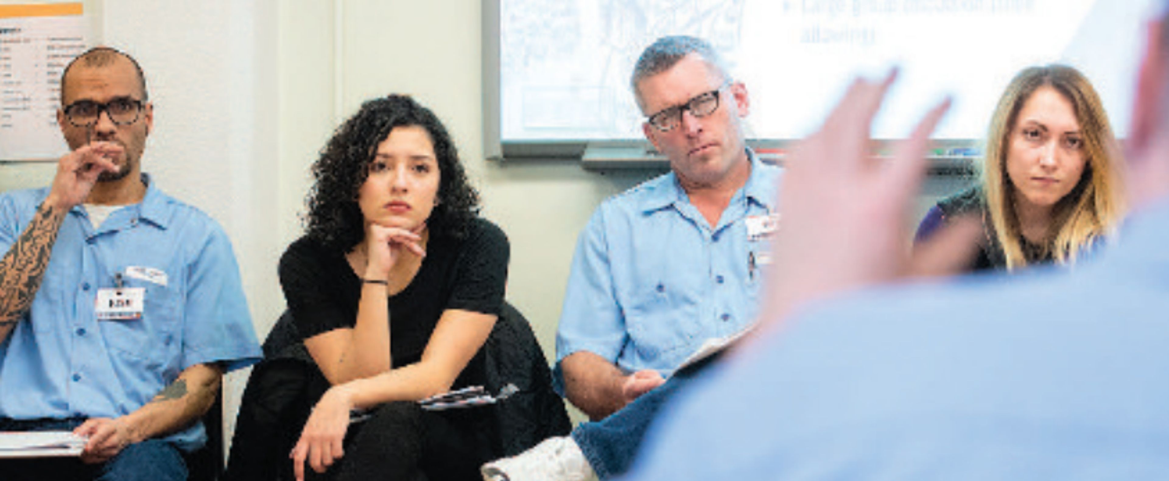 Inmates Josh and Bob sit alongside University of Idaho students Mihaela, left, and Kortni as they listen to inmate LeRoy answer a question during class last week at the Idaho Correctional Institution in Orofino.