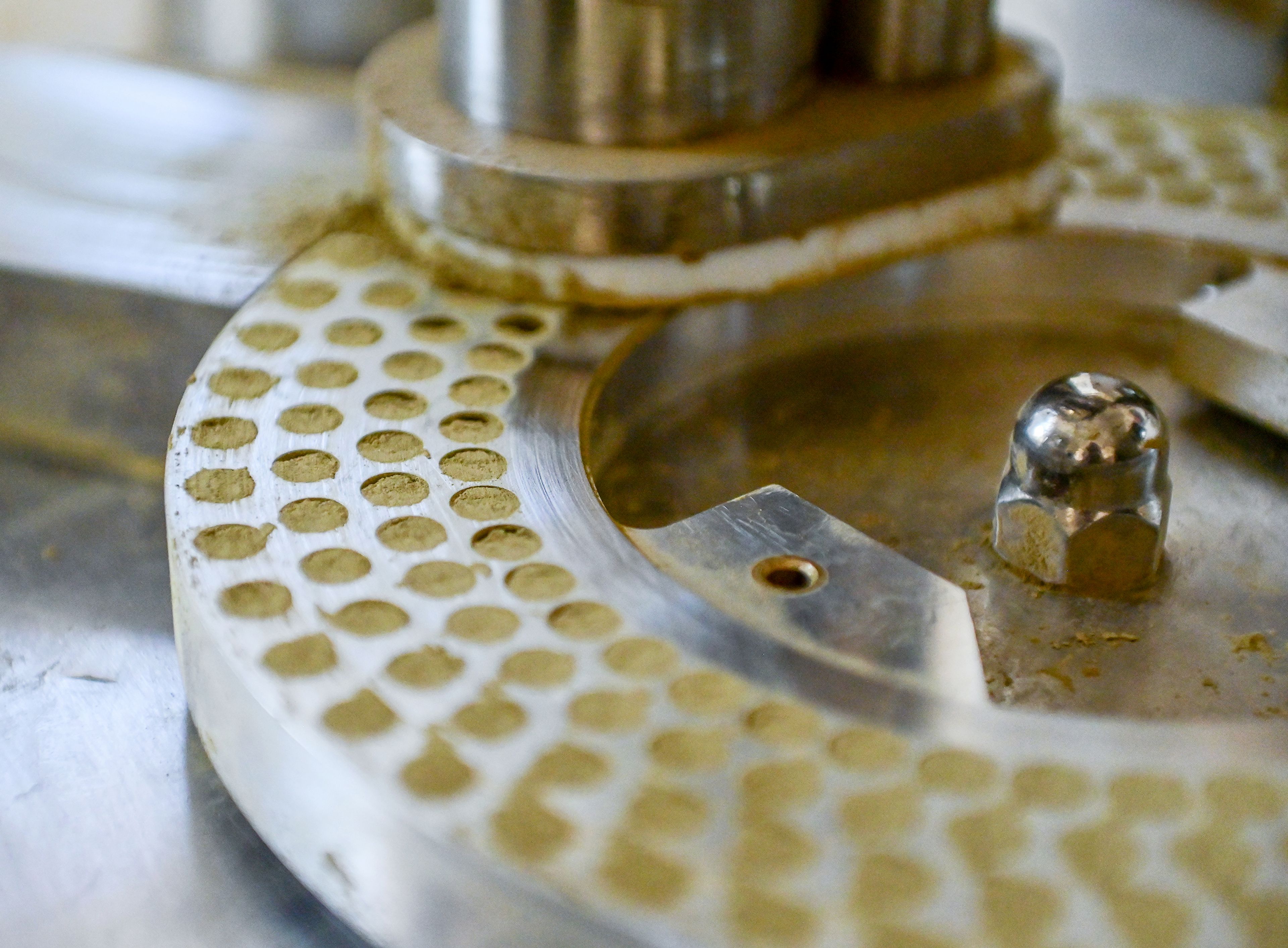 A machine is used to fill capsules with kratom powder Friday at Kratom Kings in Moscow.