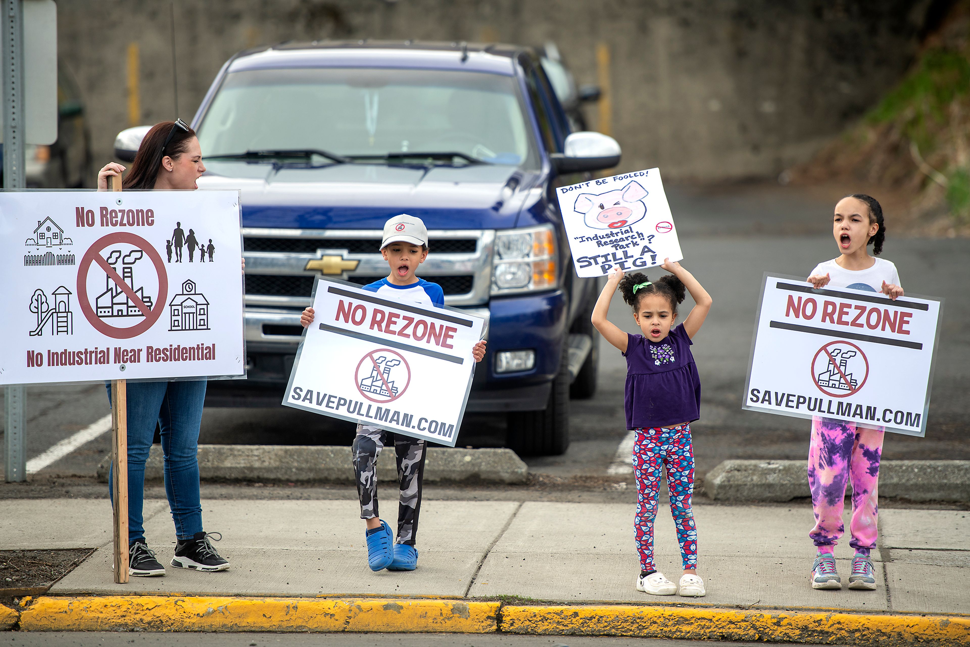 Katherine, from left, Lucas, Zara and Audrey, who only gave first names, chant on the corner of Davis Way and Grand Avenue during a protest Monday against the Port of Whitman’s decision to rezone on a residential property next to Whispering Hills neighborhood in Pullman.