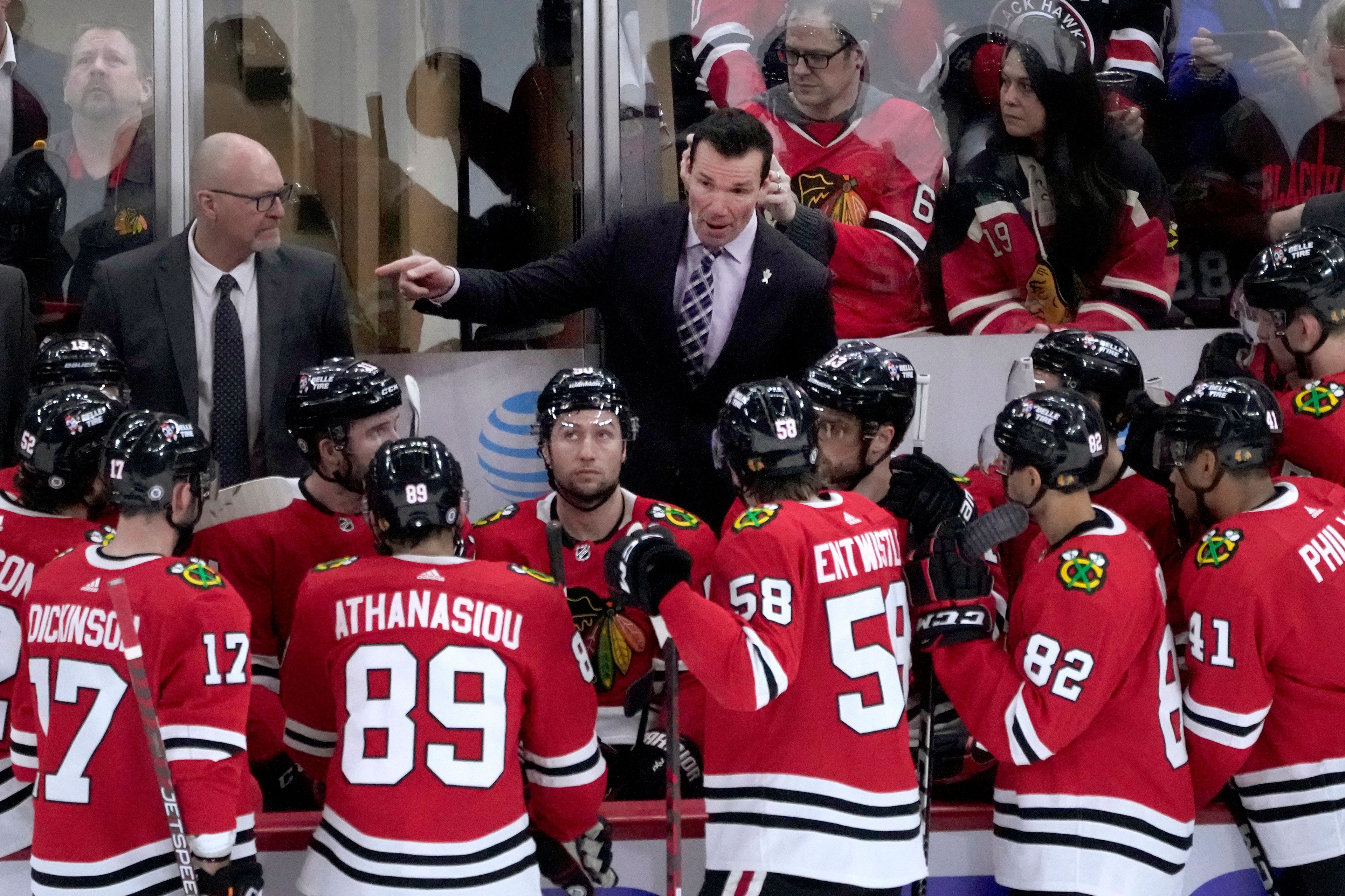 Chicago Blackhawks coach Luke Richardson, center, talks to the team after the Seattle Kraken scored for the fifth time in the first period of an NHL hockey game Saturday, Jan. 14, 2023, in Chicago. (AP Photo/Charles Rex Arbogast)