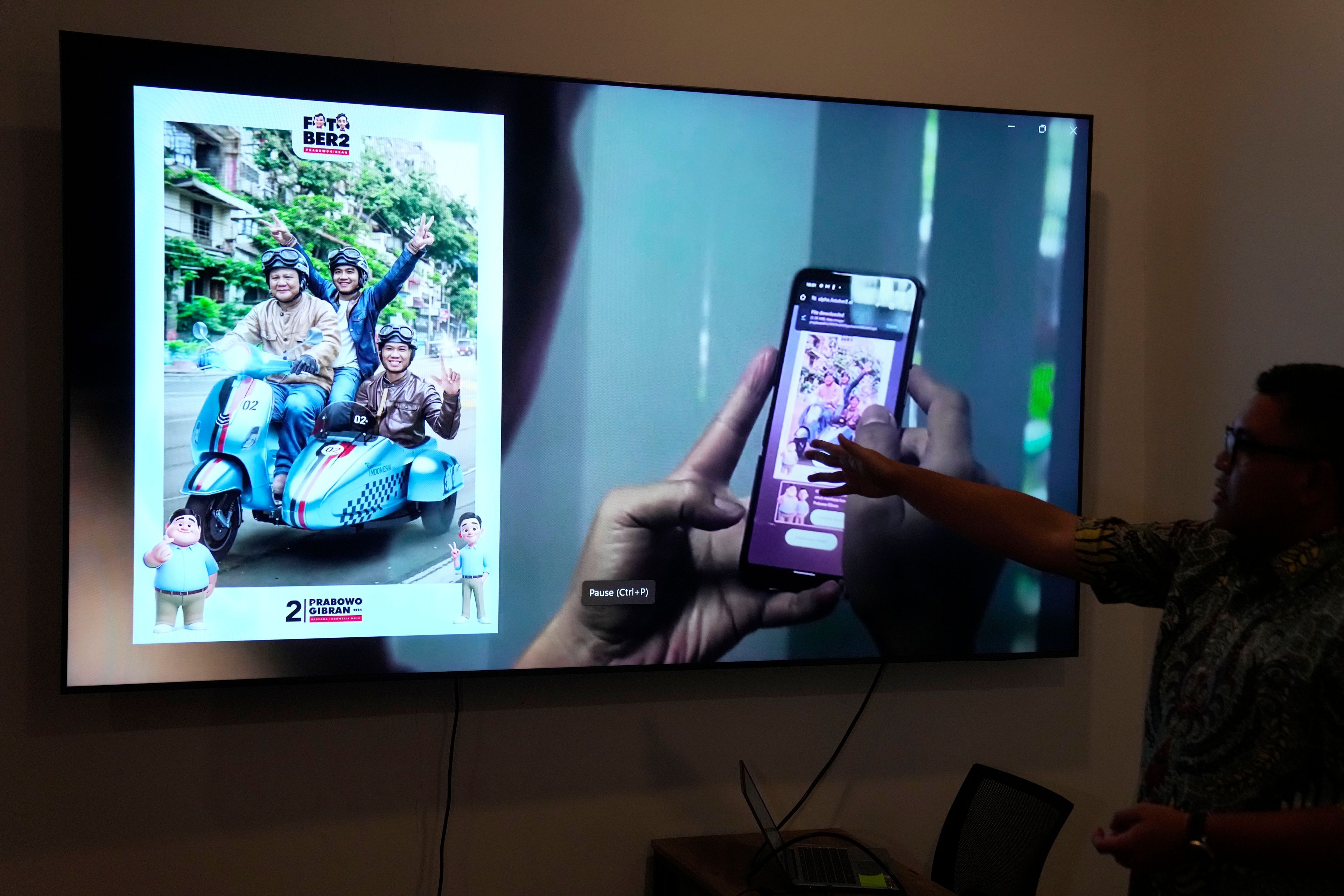 Noudhy Valdryno, the digital coordinator for the campaign team of Indonesian presidential frontrunner Prabowo Subianto, shows the interface of a web application that allows supporters to upload photos to make AI-generated images of them with Subianto, in Jakarta, Indonesia, Wednesday, Feb. 21, 2024. (AP Photo/Dita Alangkara)