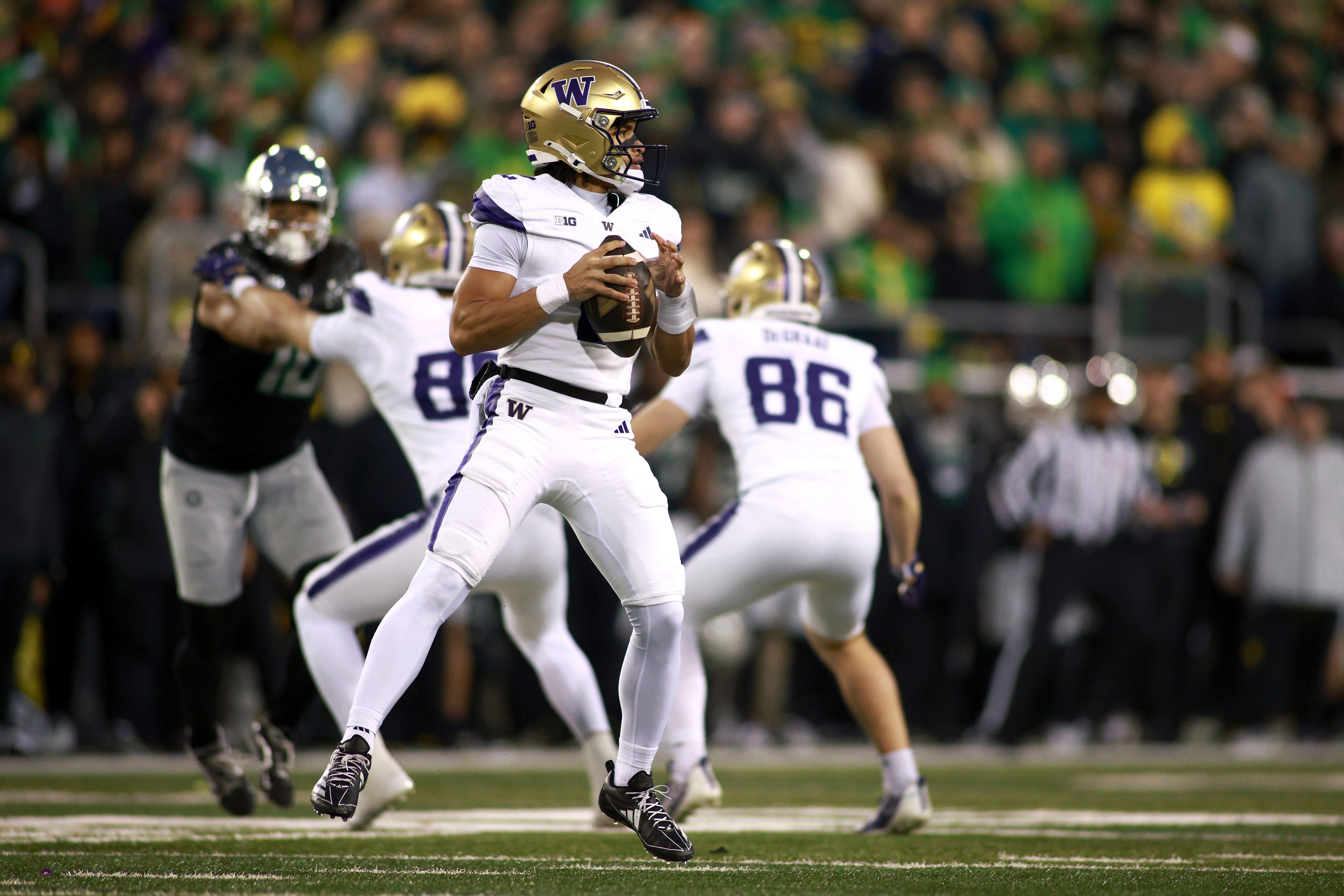 Washington quarterback Demond Williams Jr. looks for an open pass during an NCAA college football game against Oregon, Saturday, Nov. 30, 2024, in Eugene, Ore. (AP Photo/Lydia Ely)