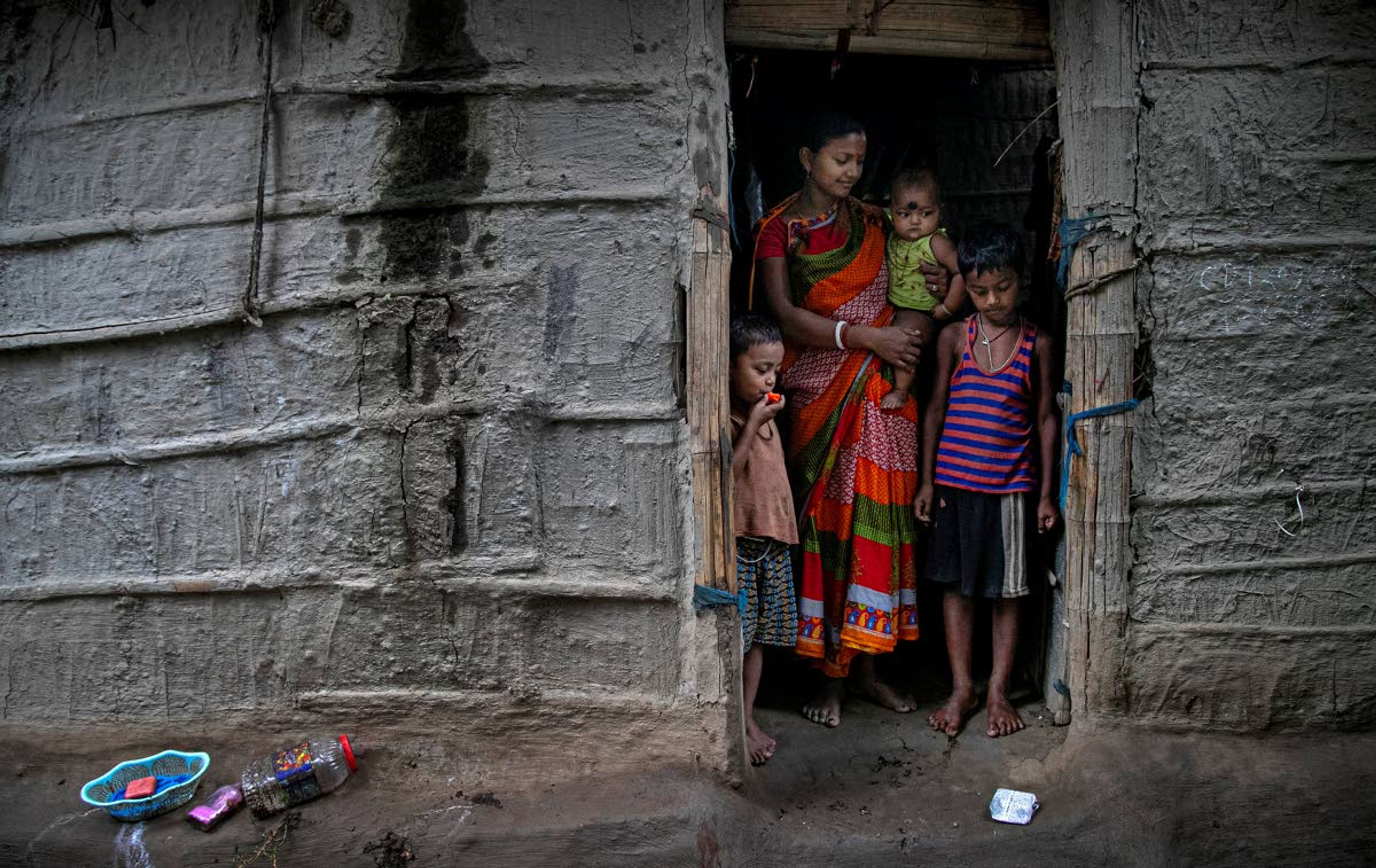 Wife and children of Ramananda Sarkar, 43, stand by the door of their house and look at the money left by Sarkar in Theng Bhanga village, in the northeastern Indian state of Assam, Tuesday, Sept. 22, 2020. Sarkar lights funeral pyres for a living. Dealing with corpses is a stigma that's only been made worse by the coronavirus, which has killed more than 100,000 people in India out of 6.4 million reported infections. After a month and a half of not seeing his wife and three sons, Sarkar snuck into his village in the middle of a recent rainy night and was able to spend 15 minutes with them and leave them some money. “I may die of COVID-19, but I don’t care," he said. "I will do my work sincerely till the end.” (AP Photo/Anupam Nath)