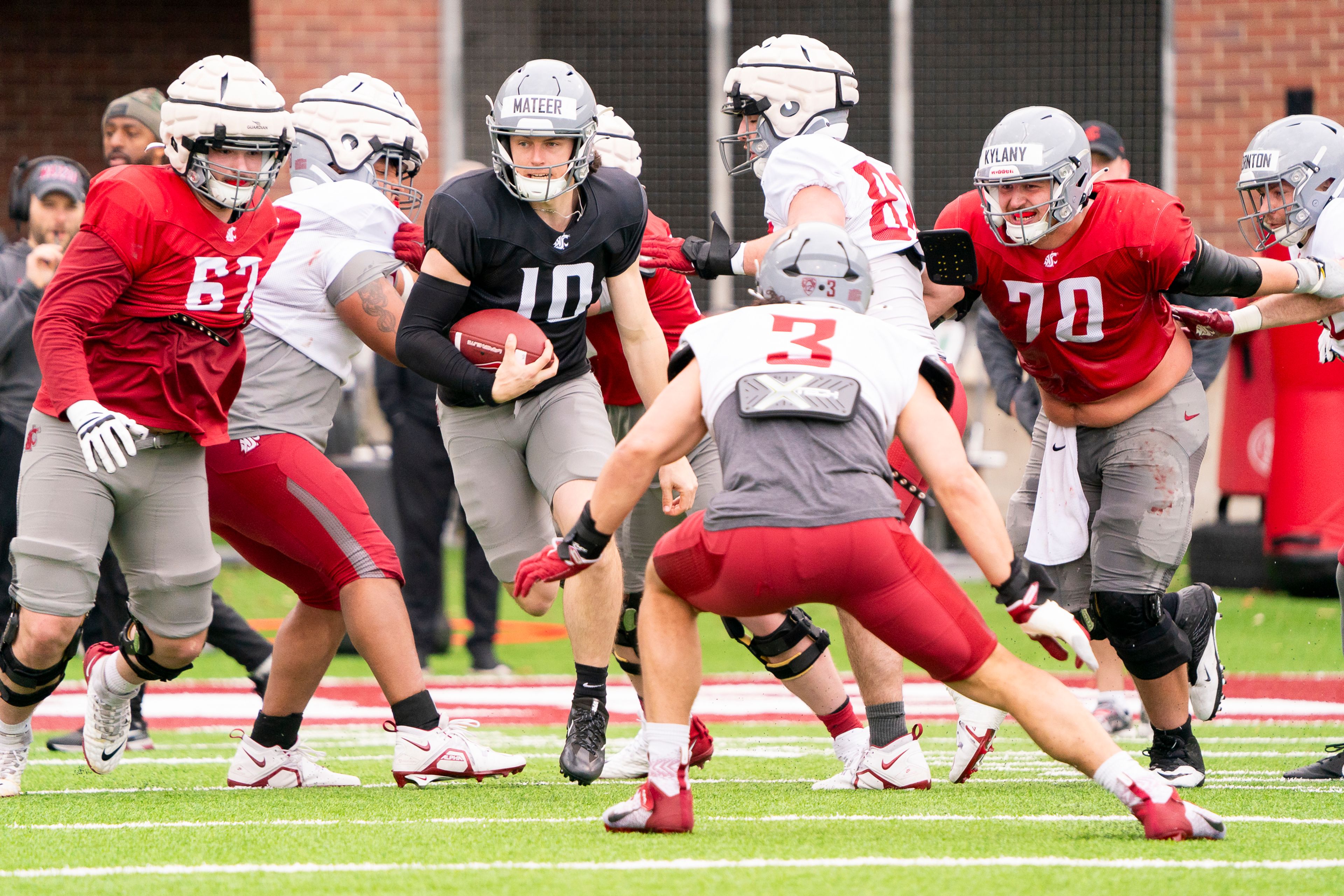 Washington State quarterback John Mateer (10) runs with the ball while edge Syrus Webster (3) defends during a practice Tuesday at Gesa Field and Rogers Field in Pullman.