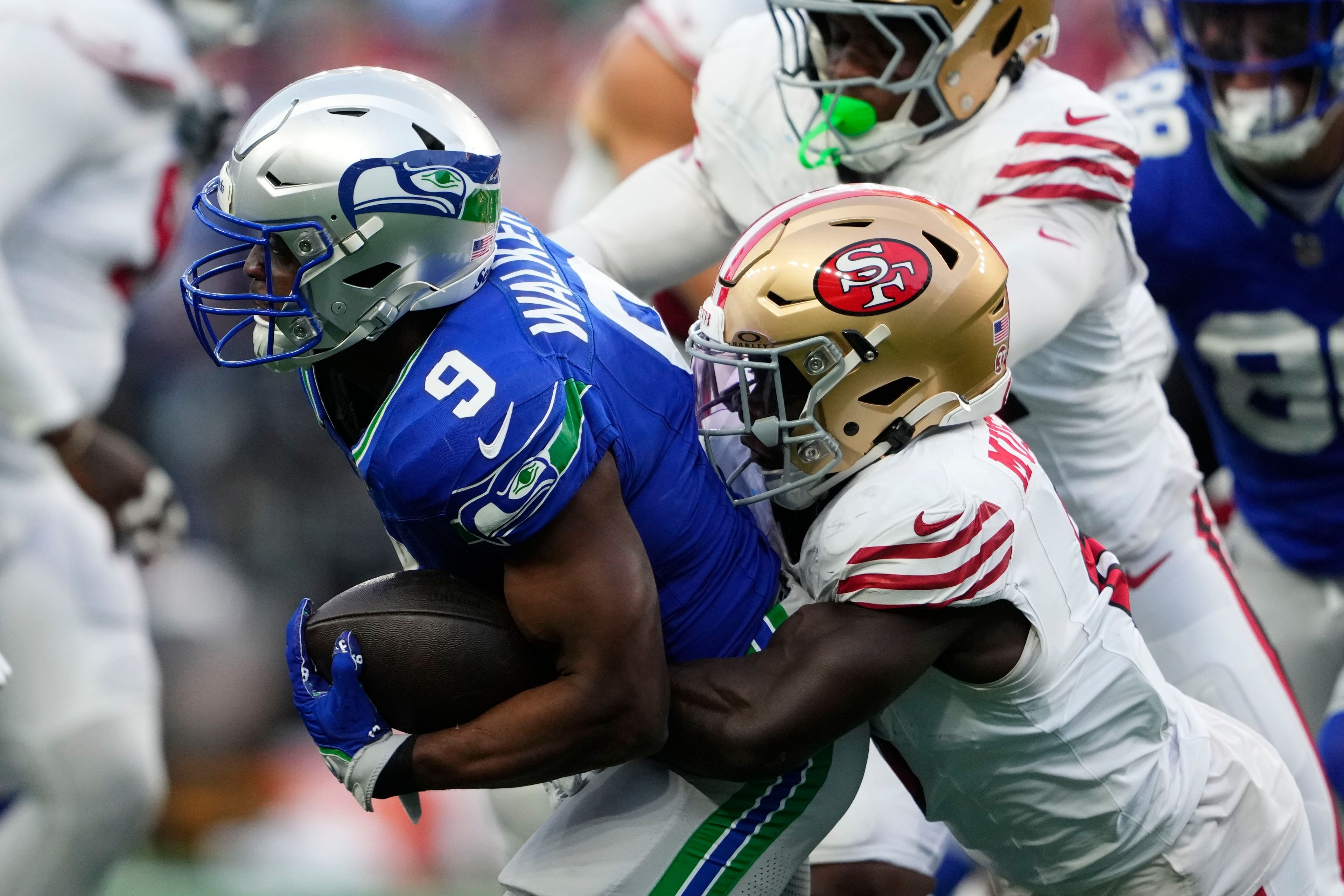 Seattle Seahawks running back Kenneth Walker III (9) is tackled by San Francisco 49ers' Malik Mustapha (6) during the first half of an NFL football game, Thursday, Oct. 10, 2024, in Seattle. (AP Photo/Lindsey Wasson)