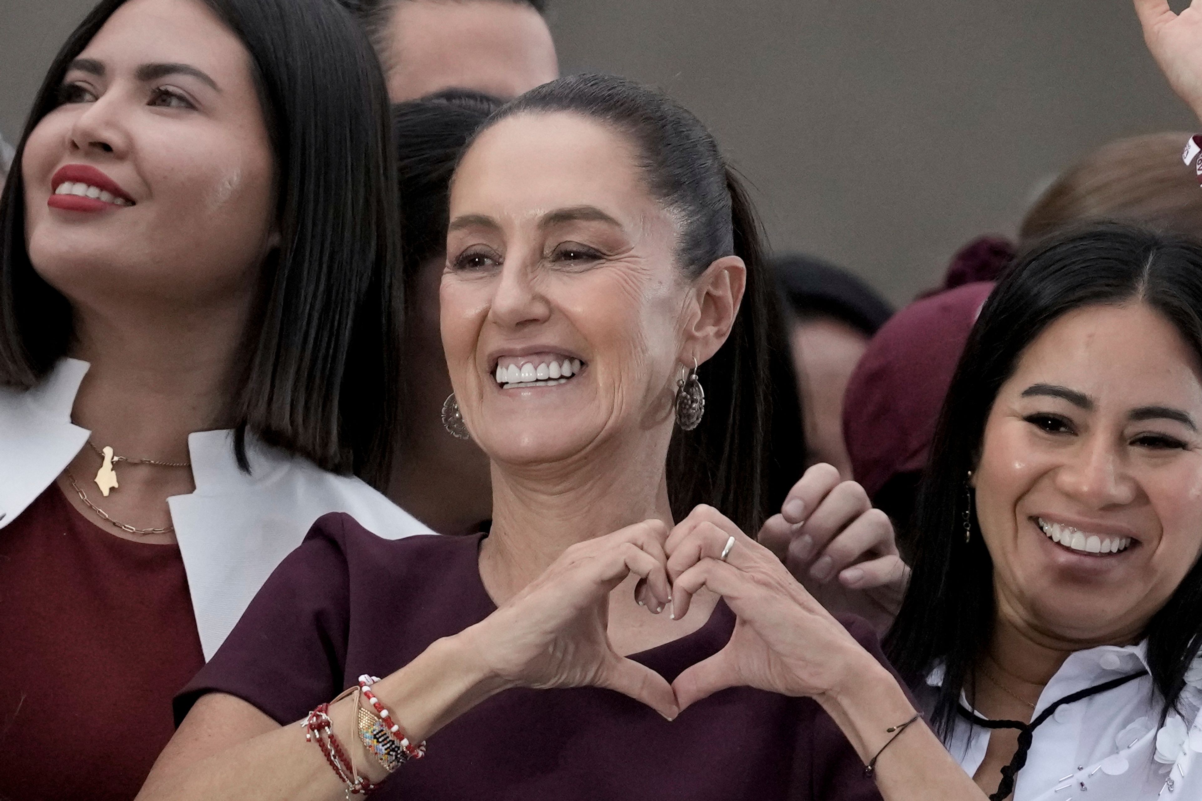 FILE - Presidential candidate Claudia Sheinbaum flashes a hand-heart sign during her closing campaign rally at the Zocalo in Mexico City, May 29, 2024. Sheinbaum, a climate scientist and former Mexico City mayor, will be sworn in as Mexicoâ€™s first woman president on Oct. 1. (AP Photo/Eduardo Verdugo, File)