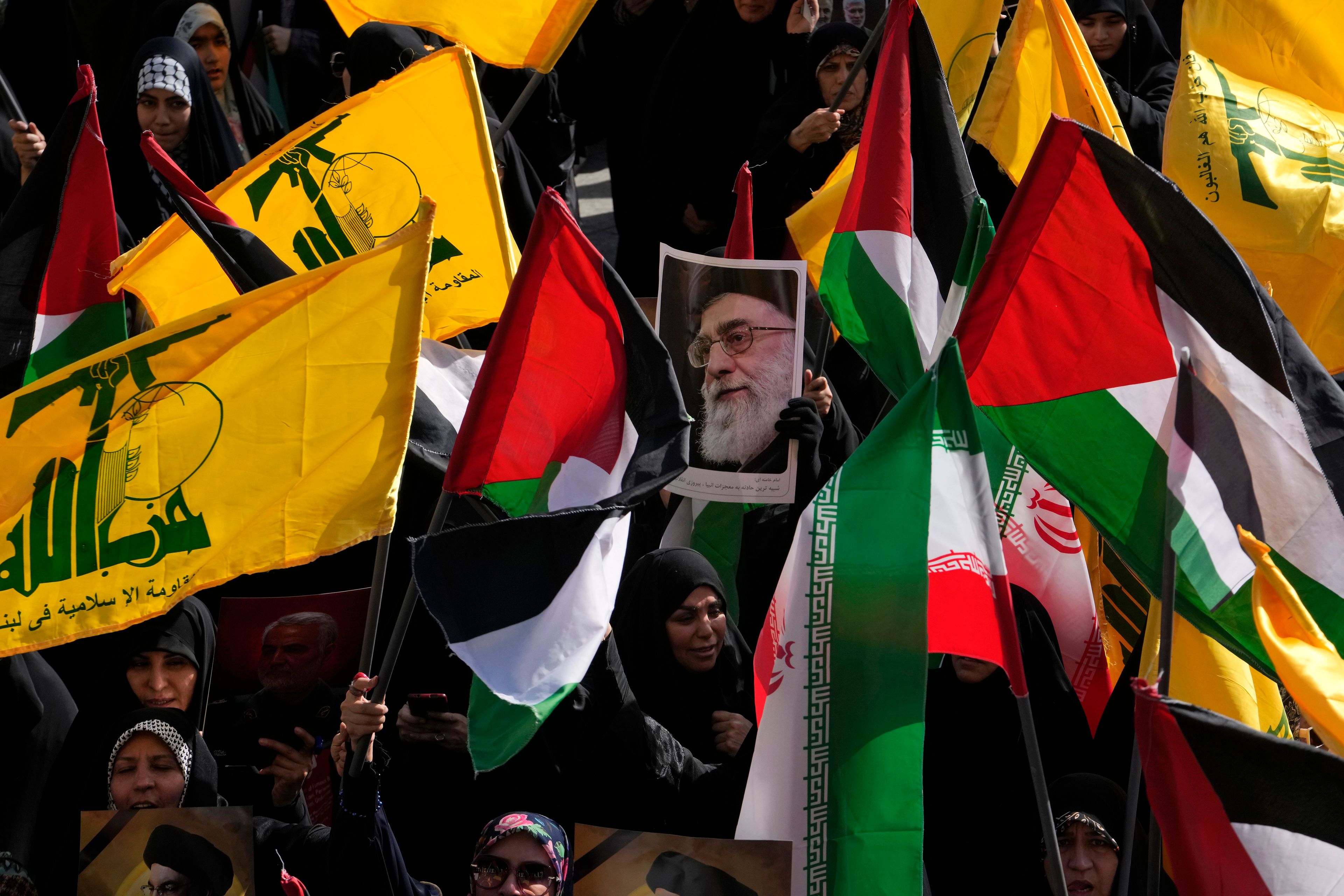 Demonstrators hold Iranian, Palestinian and Hezbollah flags and a poster of the Iranian Supreme Leader Ayatollah Ali Khamenei in a rally commemorating slain Hezbollah leader Hassan Nasrallah, in Tehran, Iran, Wednesday, Oct. 2, 2024. (AP Photo/Vahid Salemi)