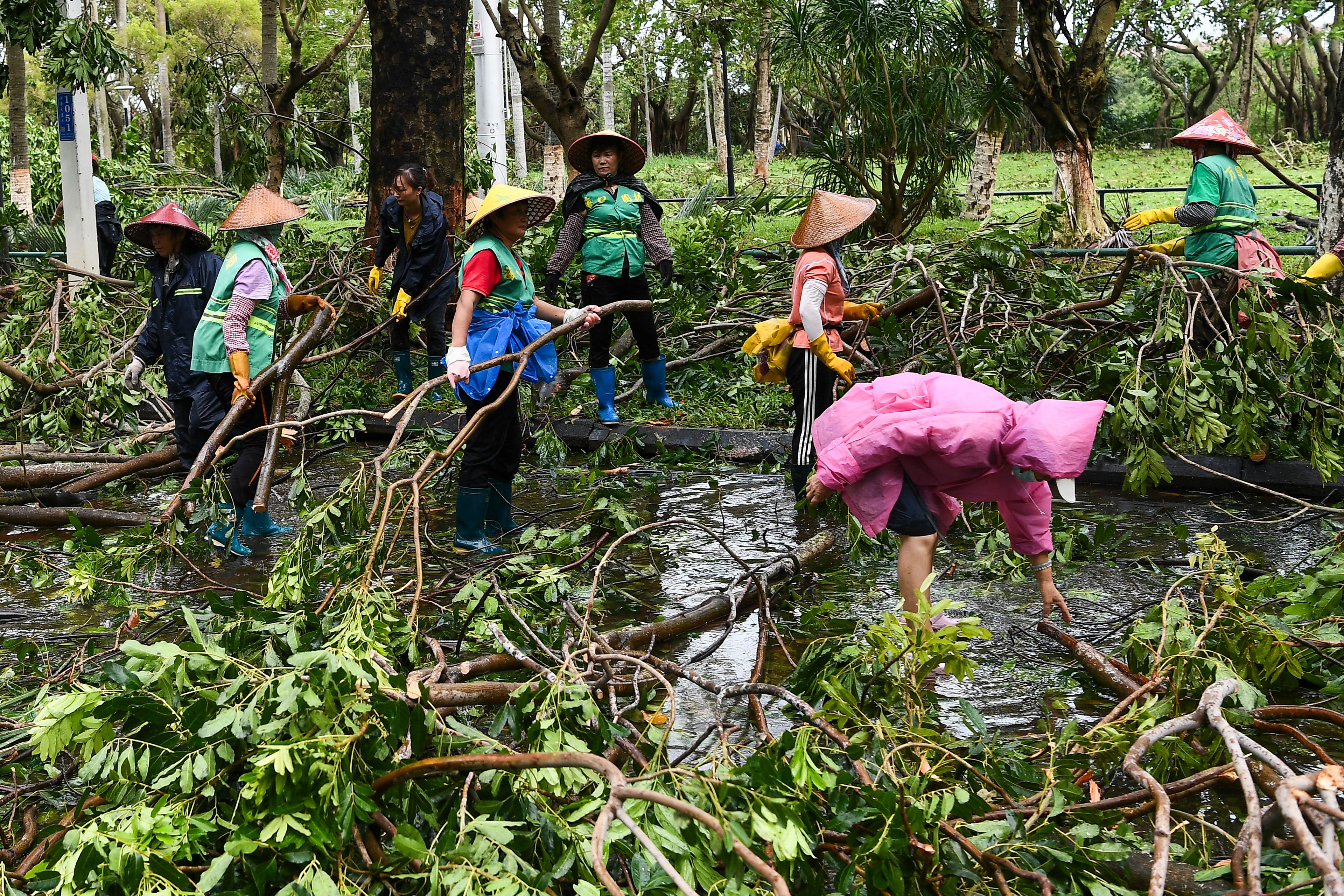 In this photo released by Xinhua News Agency, workers remove fallen tree branches along a street in the aftermath of Typhoon Yagi in Haikou, south China's Hainan Province, Saturday, Sept. 7, 2024.