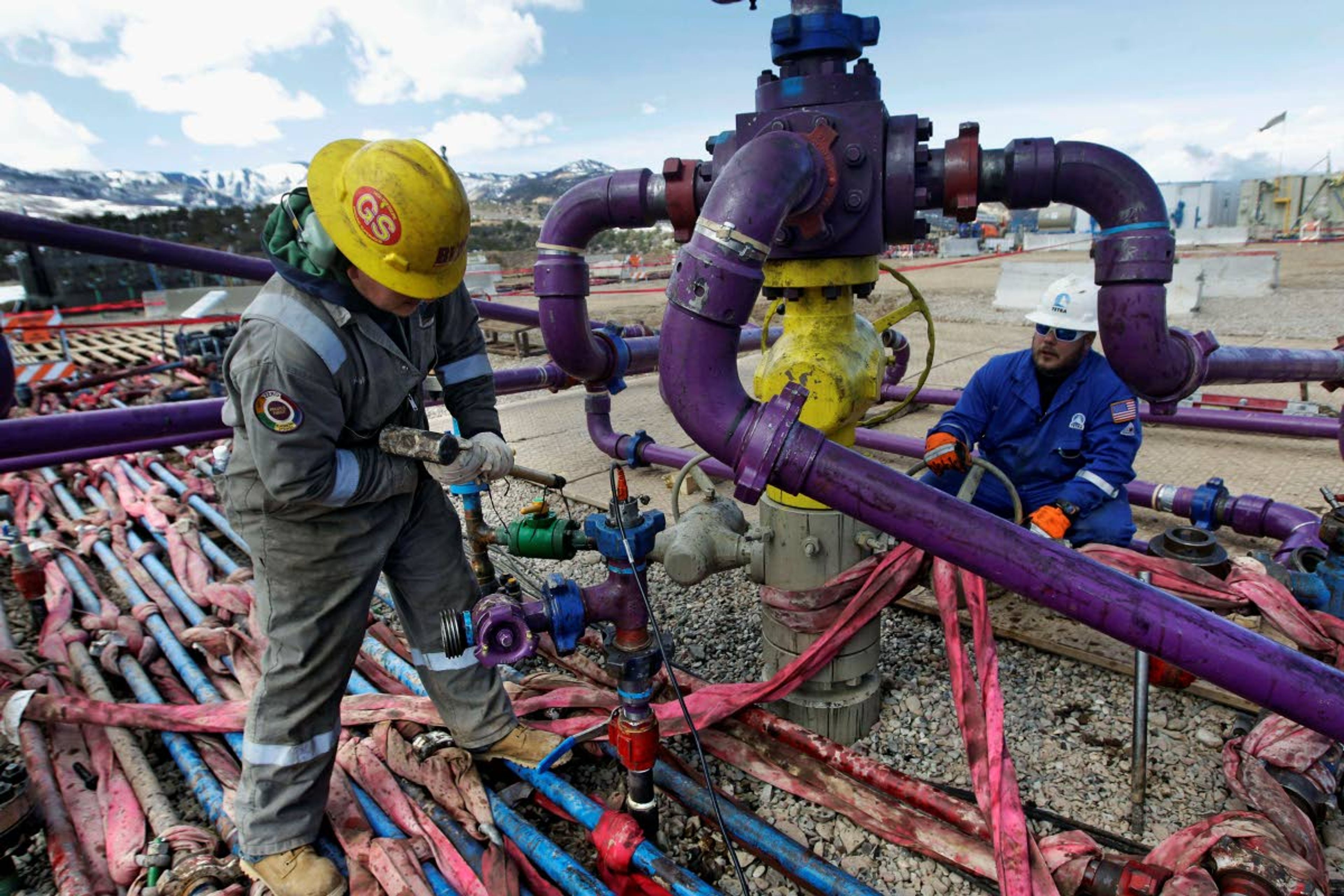 FILE - In this March 29, 2013, file photo, workers tend to a well head during a hydraulic fracturing operation outside Rifle, in western Colorado. A judge has blocked oil and gas drilling on almost 500 square miles in Wyoming and says the government must consider cumulative climate change impacts of leasing public lands across the U.S. for energy development. The order marks the latest in a string of court rulings over the past decade faulting the government's consideration of emissions when issuing energy leases. (AP Photo/Brennan Linsley, File)