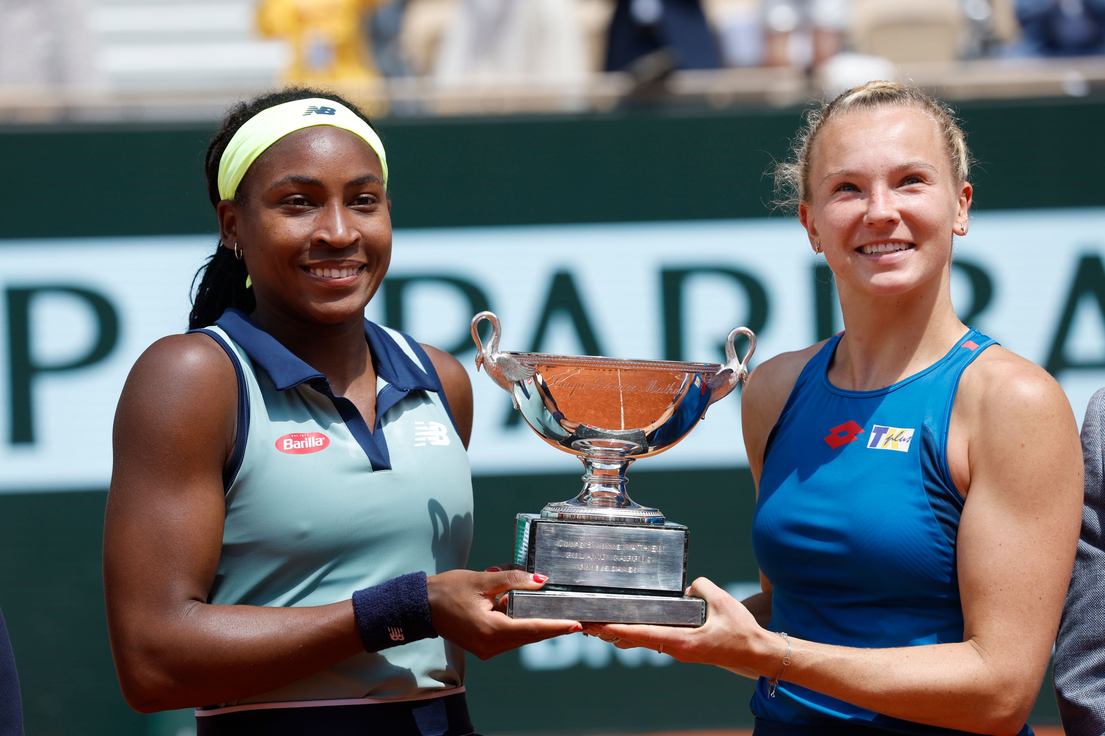 Coco Gauff of the U.S., left, and Katerina Siniakova of the Czech Republic hold the trophy as they won the women's doubles final match of the French Open tennis tournament against Italy's Sara Errani and Jasmine Paolini at the Roland Garros stadium in Paris, Sunday, June 9, 2024.