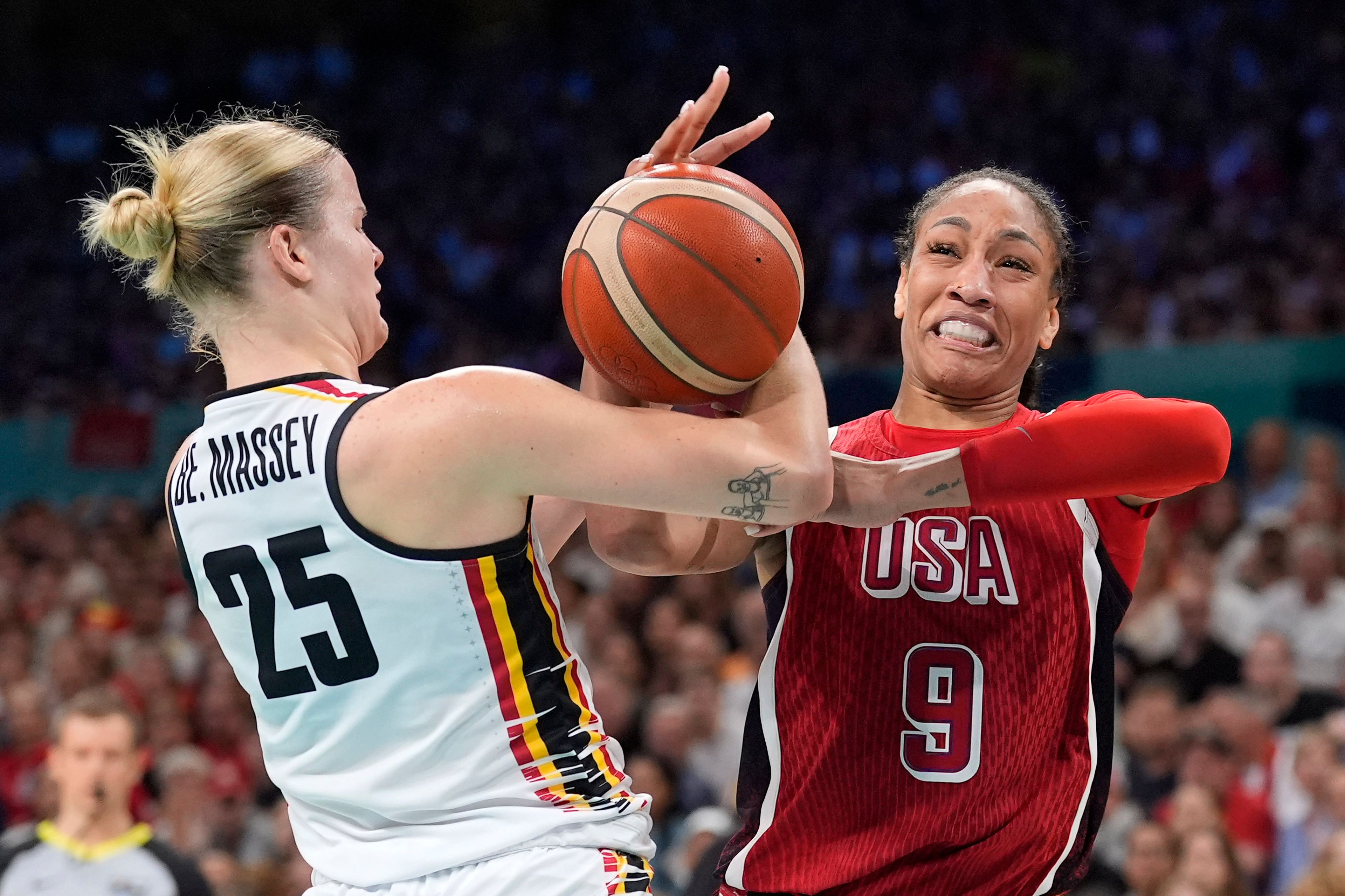 Belgium's Beckey Massey, left, and United States' A'ja Wilson grapple for the ball during a women's basketball game at the 2024 Summer Olympics, Thursday, Aug. 1, 2024, in Villeneuve-d'Ascq, France. (AP Photo/Michael Conroy)