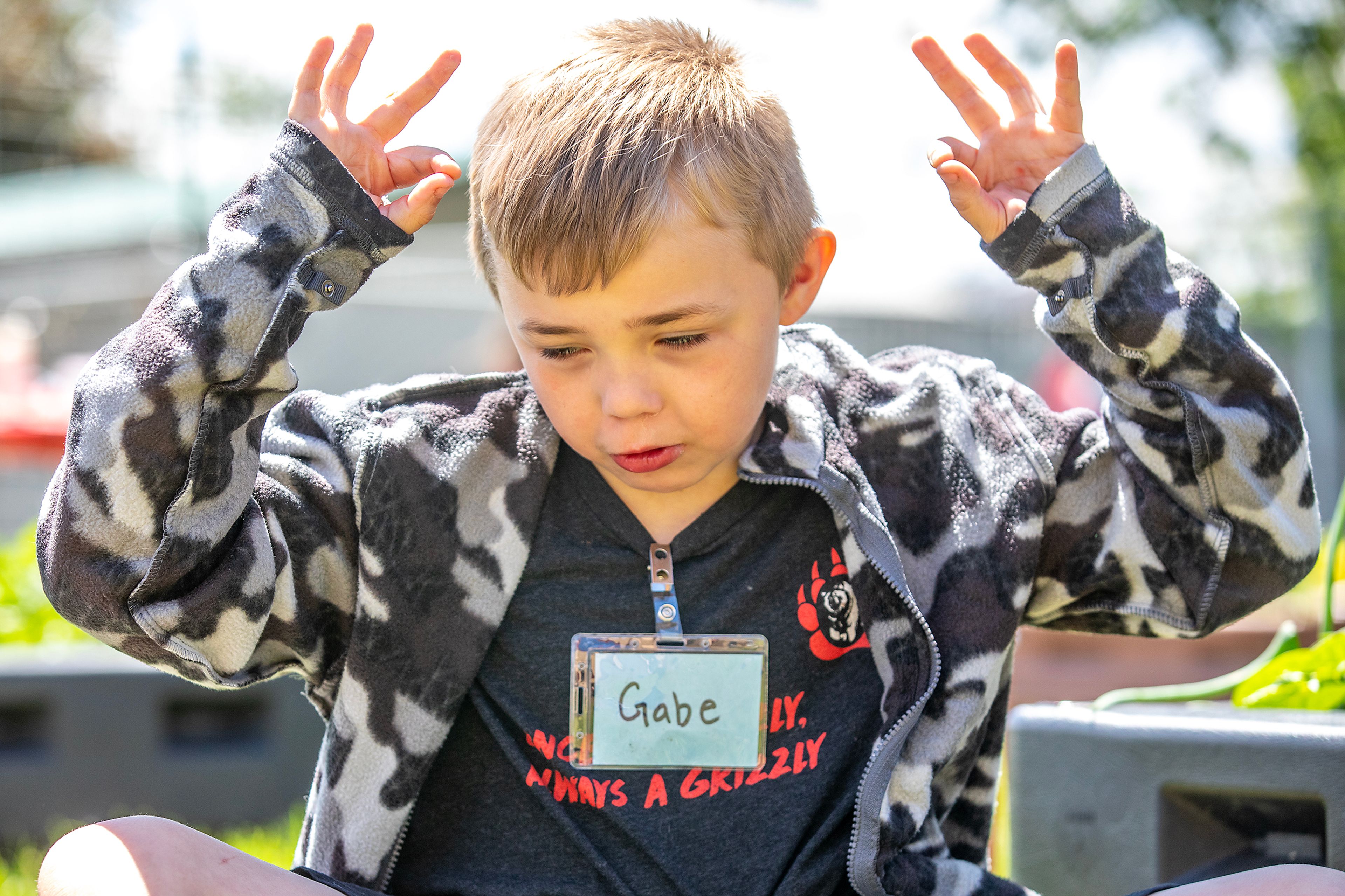 Gabe Anderson, 7, puts his fingers up when asked what he thinks of the salad his class and others helped grow at Grantham Elementary Monday in Clarkston.