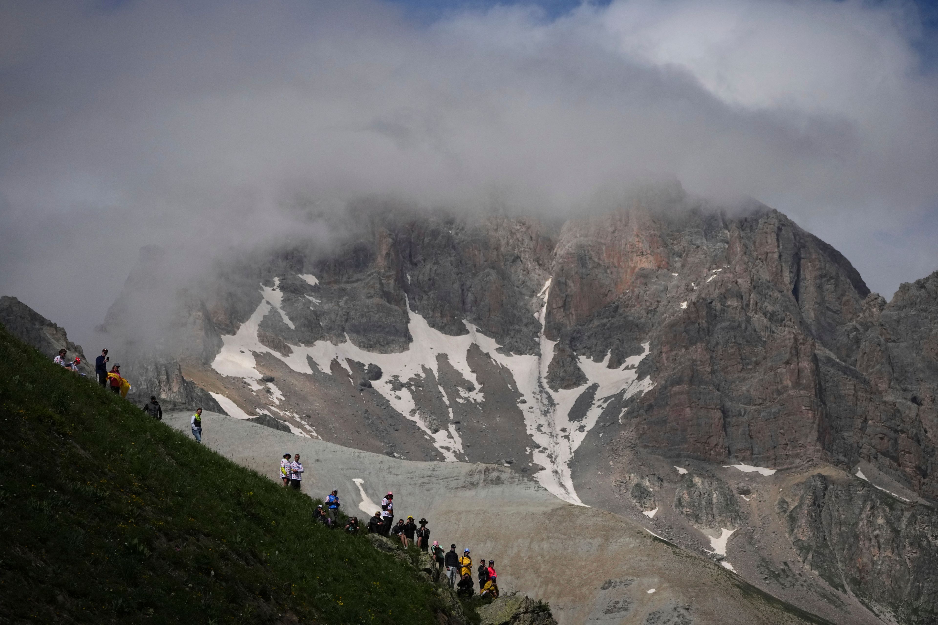 Spectators wait the riders to pass in the Col du Galibier during the fourth stage of the Tour de France cycling race over 139.6 kilometers (86.7 miles) with start in Pinerolo, Italy and finish in Valloire, France, Tuesday, July 2, 2024. (AP Photo/Daniel Cole)