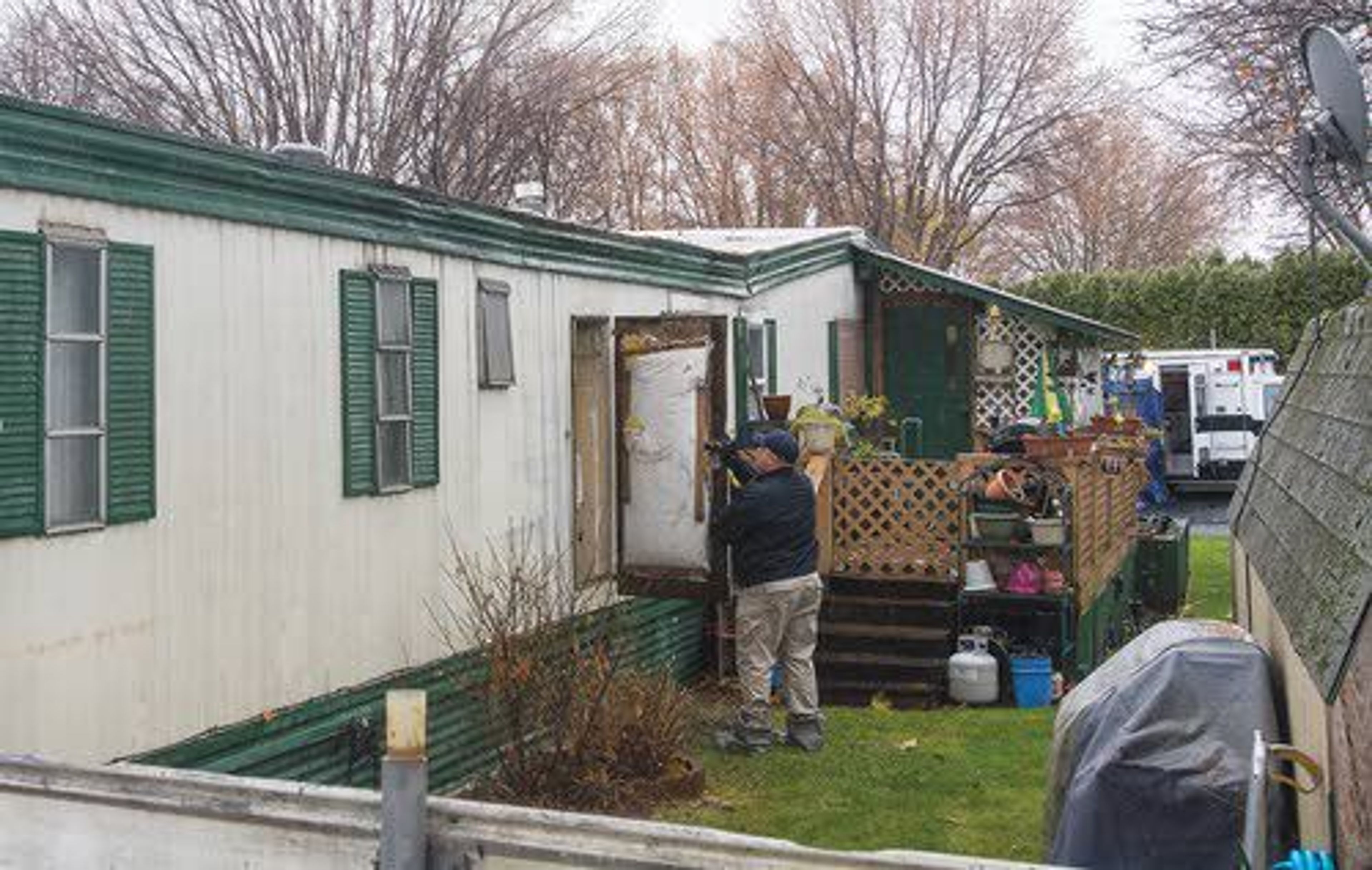 Investigators from the Lewiston Police Department look through one of two mobile homes that was the scene of a double homicide Tuesday morning on the 600 block of Preston Avenue in Lewiston.