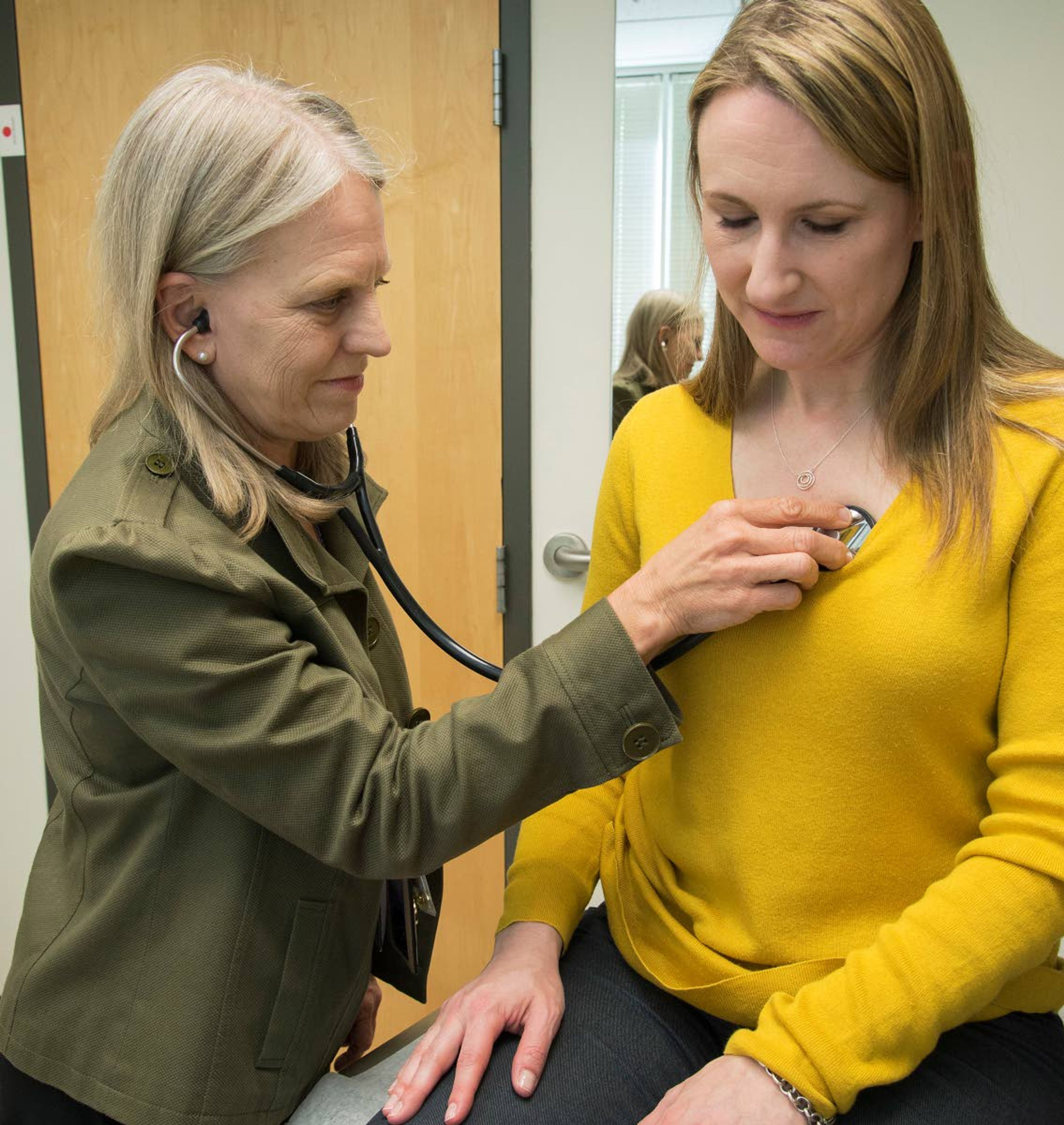 CORRECTS LOCATION TO SEATTLE, NOT ARLINGTON - In this 2016 photo provided by the University of Washington, Dr. Linda Vorvick examines Heather VanDusen at UW Neighborhood Clinic in Seattle. When emergency tests showed the telltale right-sided pain in VanDusen's abdomen was appendicitis, she figured she'd be quickly wheeled into surgery. But doctors offered her the option of antibiotics instead. (Clare McLean/UW Medicine via AP)