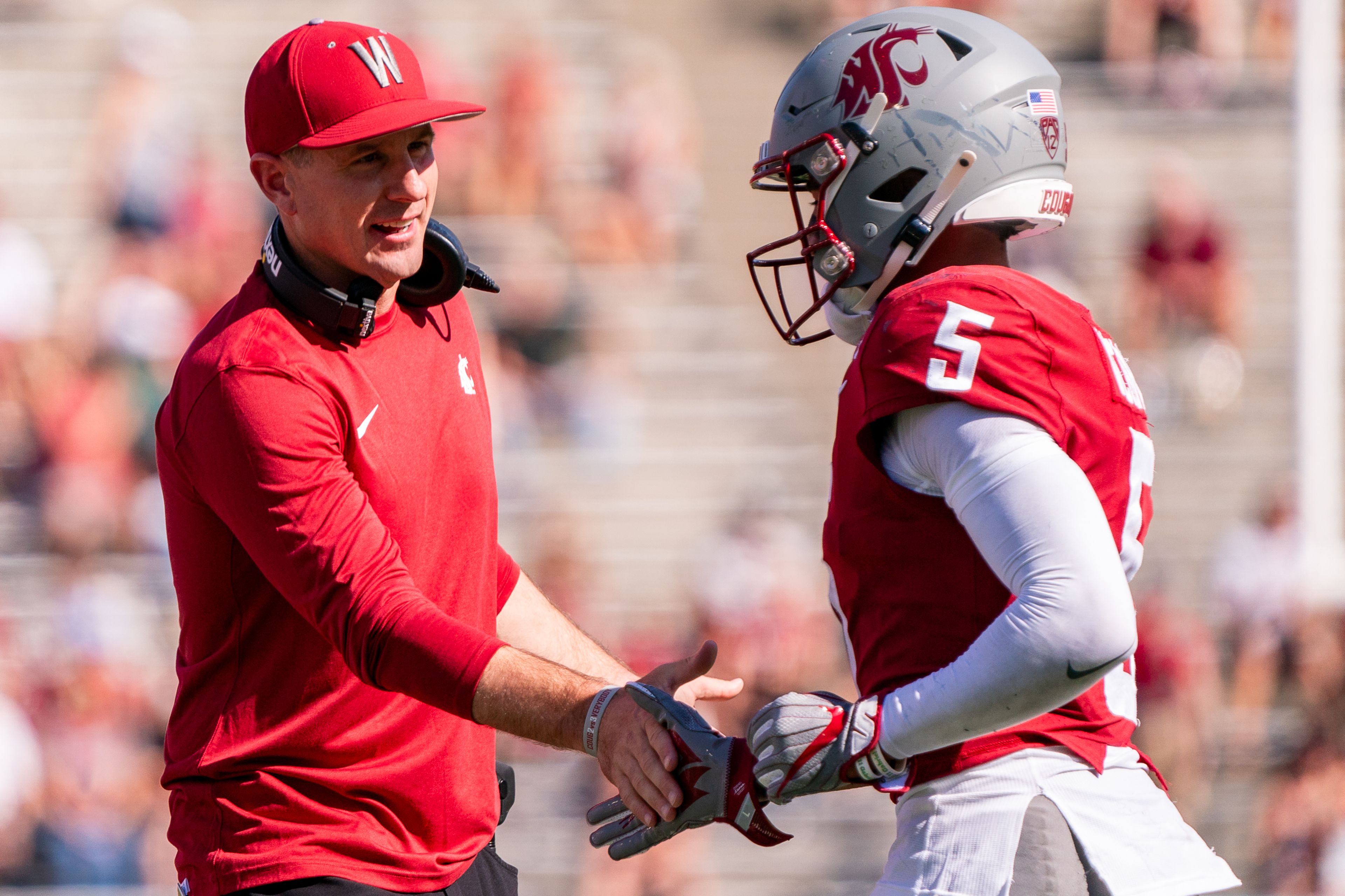 Washington State Cougars coach Jake Dickert, left, high-fives wide receiver Lincoln Victor (5) after scoring during their game against Northern Colorado on Sept. 16 at Martin Stadium in Pullman.