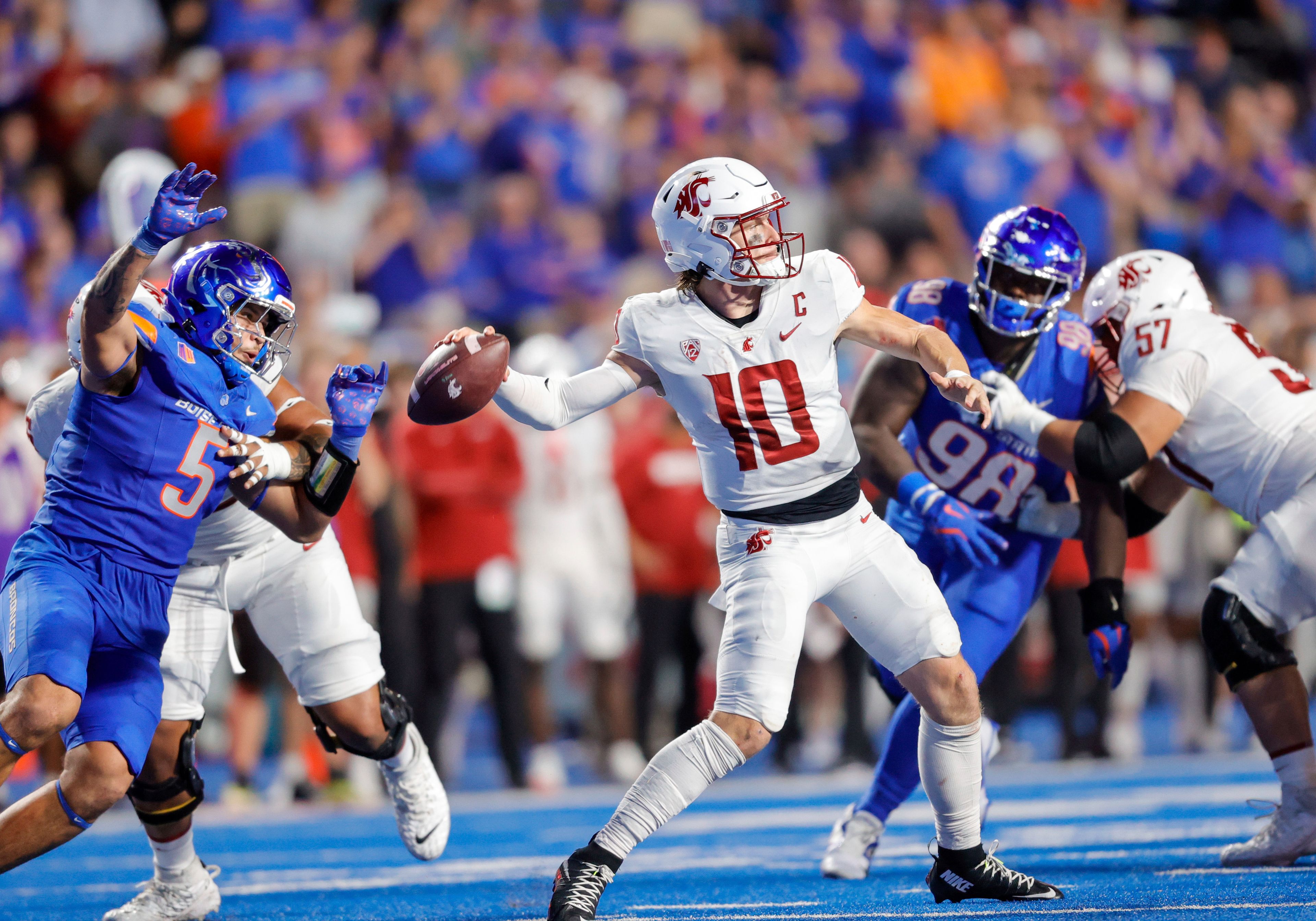 Washington State quarterback John Mateer (10) throws the ball while pressured by Boise State defensive end Jayden Virgin-Morgan (5) late in the second half of an NCAA college football game, Saturday, Sept. 28, 2024, in Boise, Idaho. (AP Photo/Steve Conner)