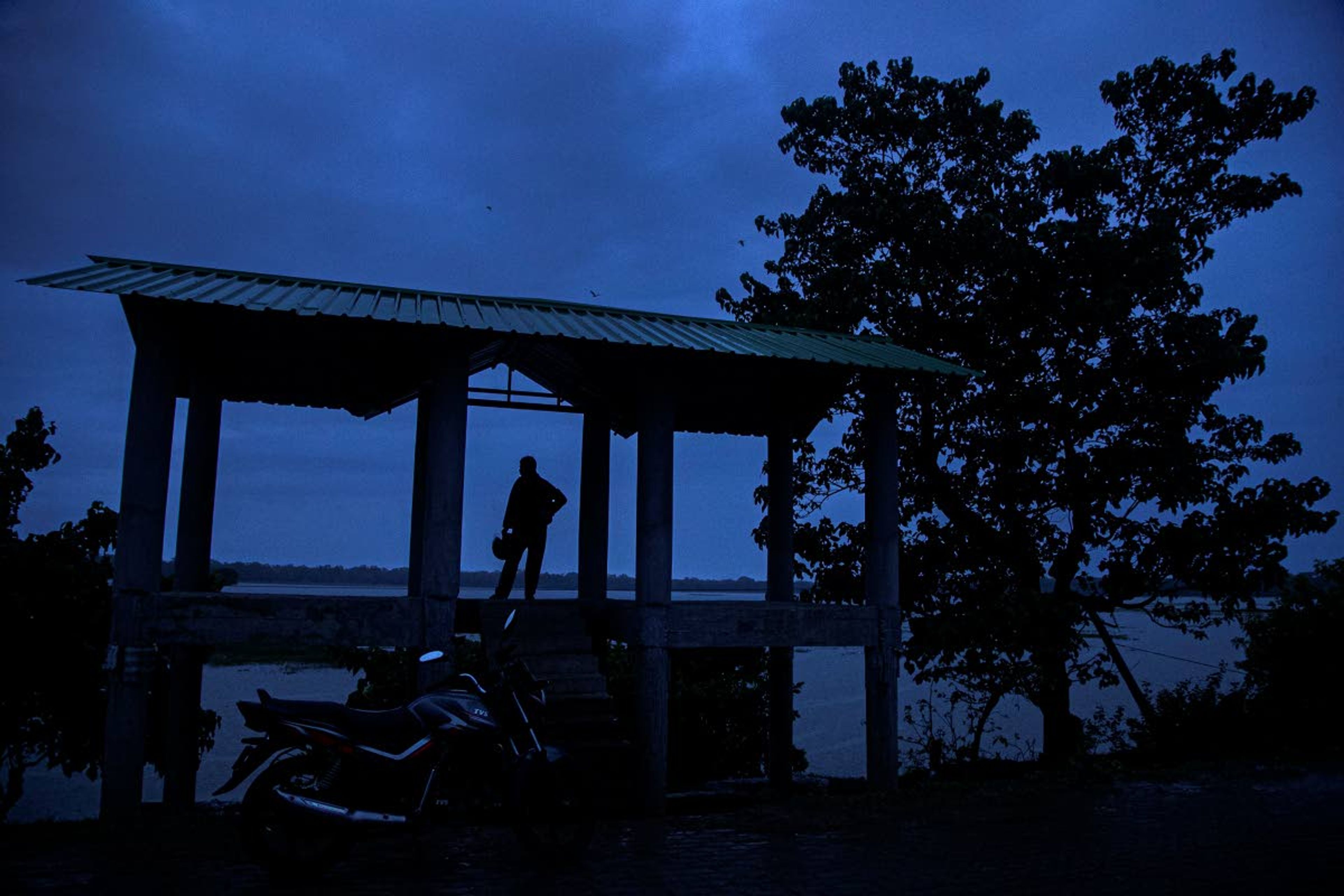 Ramananda Sarkar, 43, takes a restwhile journeying towards his village to visit his family, early morning in Pobitora, in the notheastern Indian state of Assam, Tuesday, Sept. 22, 2020. While Hindu's believe cremation rights are sacred and release the dead person's soul from the cycle of rebirth, those who actually deal with corpses are looked down upon. After a month and a half of not seeing his wife and three sons, Sarkar snuck into his village in the middle of a recent rainy night. He called out to his family from the road outside his house and was able to spend 15 minutes with them and leave them some money. (AP Photo/Anupam Nath)