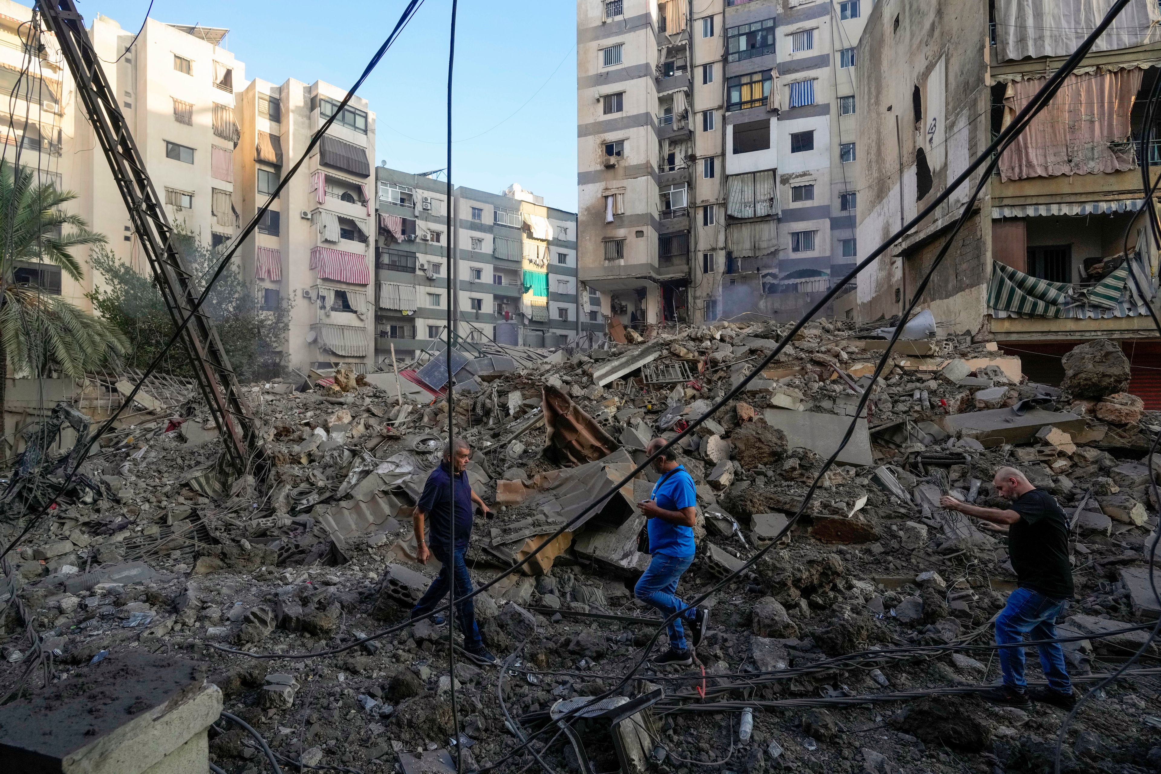 People check damaged buildings at the site of an Israeli airstrike in Dahiyeh, Beirut, Lebanon, Friday, Oct. 4, 2024. (AP Photo/Hassan Ammar)