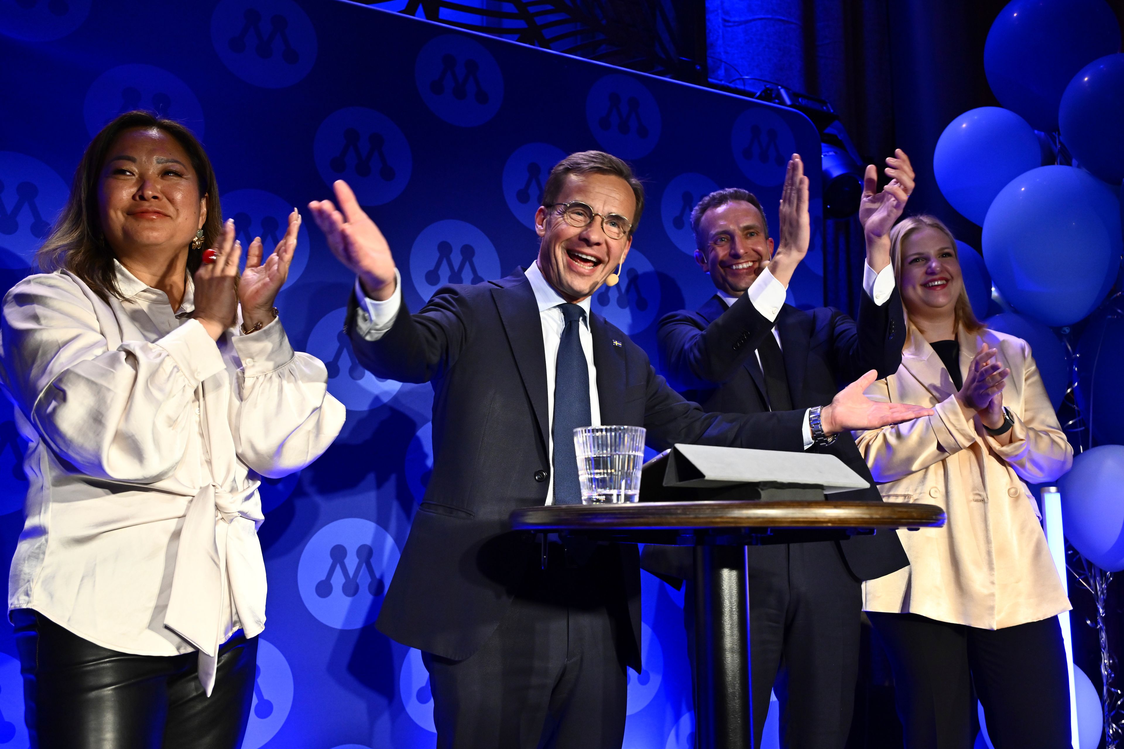 The Moderates' top candidate for the EU elections, Jessica Polfjärd, left, Prime Minister Ulf Kristersson, center, and the Moderates' top candidate for the EU elections Tomas Tobé applaud at the Moderates' election watch party at the Library restaurant in Stockholm, Sunday, June 9, 2024.