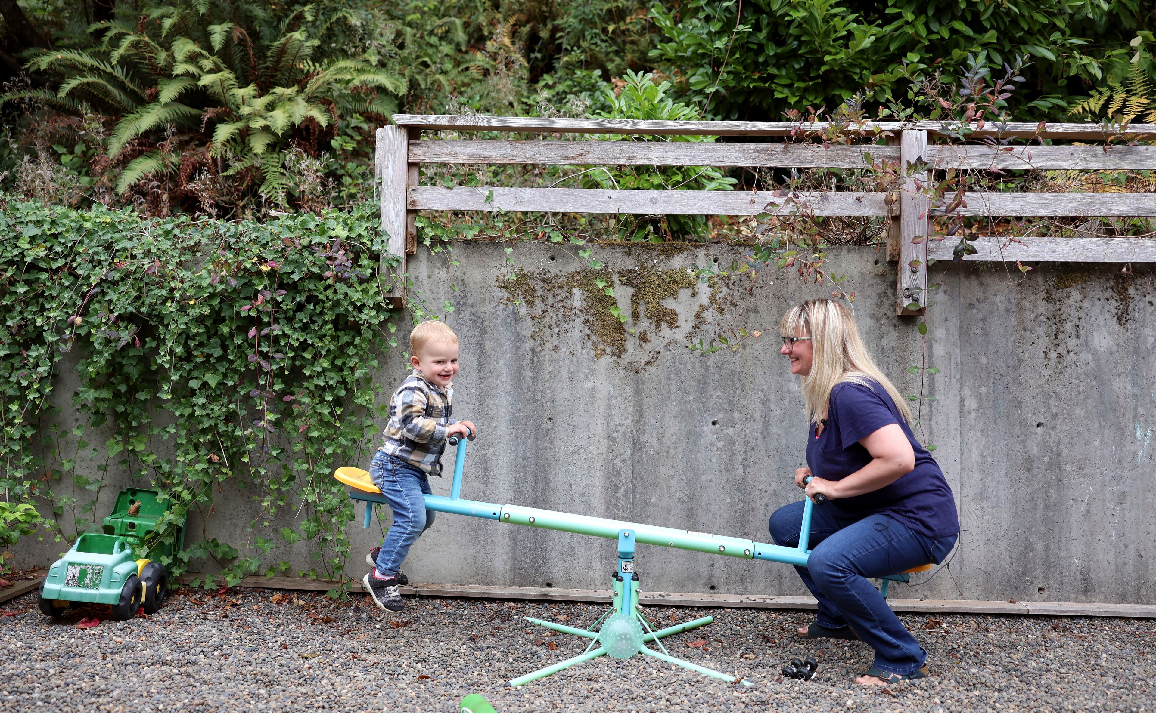 Karli Neilson plays with her son Axel, 2, in Gearhart, Ore., Friday, Sept. 2, 2022. Neilson has alternated between having to take time off work and working part-time so as to watch her 2-year-old son. She hasn't been able to find formal care for him since he was born in August 2020. "It just got to be like a part-time job just doing the research and trying to find a place," Nielsen said. (AP Photo/Craig Mitchelldyer)