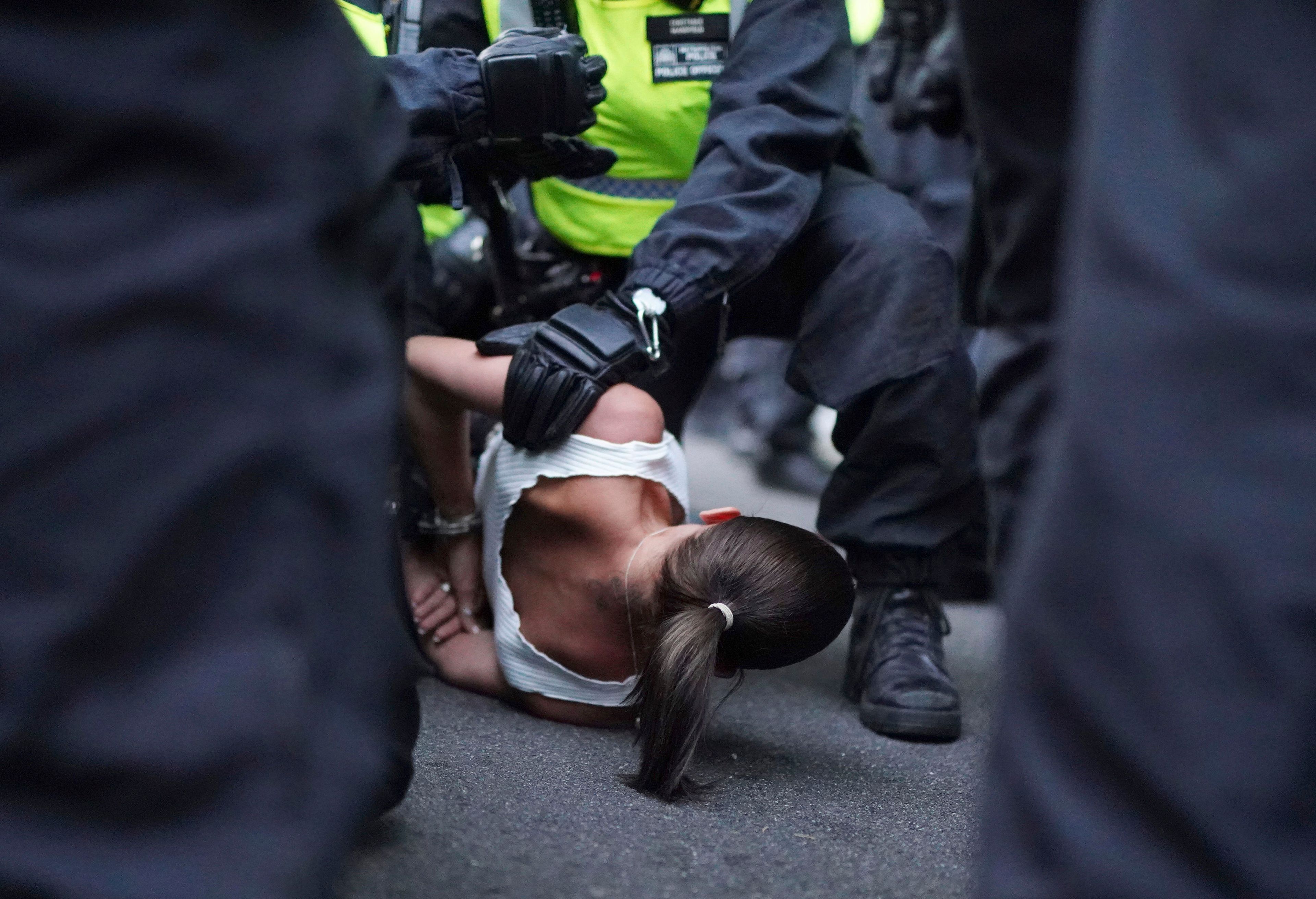 A woman is detained as people attend the 'Enough is Enough' protest in Whitehall, London, Wednesday July 31, 2024, following the fatal stabbing of three children at a Taylor Swift-themed holiday club on Monday in Southport. (Jordan Pettitt/PA via AP)