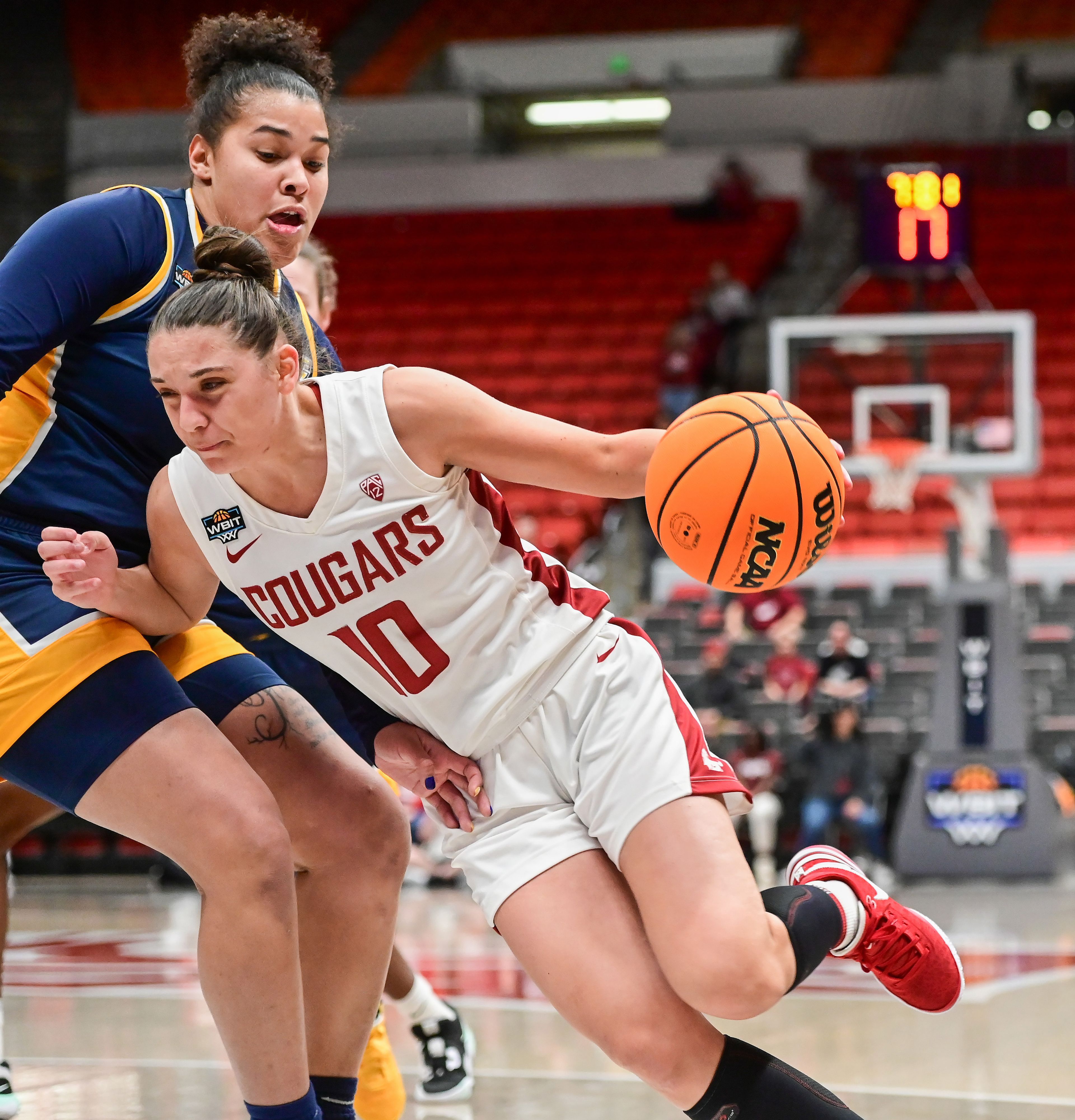 Washington State guard Eleonora Villa (10) pushes past Toledo Rockets forward Nan Garcia (1) in a drive for the net during a WBIT game March 28 in Pullman.,