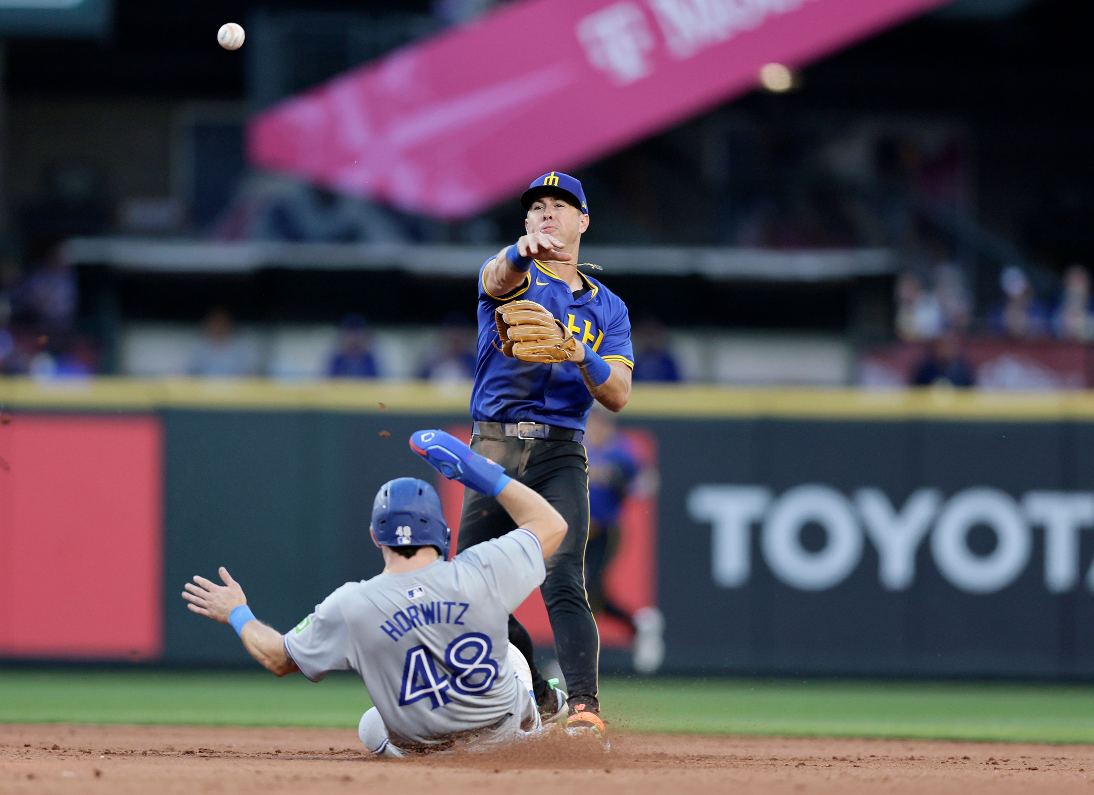 Toronto Blue Jays' Spencer Horwitz (48) is forced out at second as Seattle Mariners second baseman Dylan Moore, top, throws to first to complete a double play against Blue Jays' Bo Bichette during the sixth inning in a baseball game, Friday, July 5, 2024, in Seattle. (AP Photo/John Froschauer)