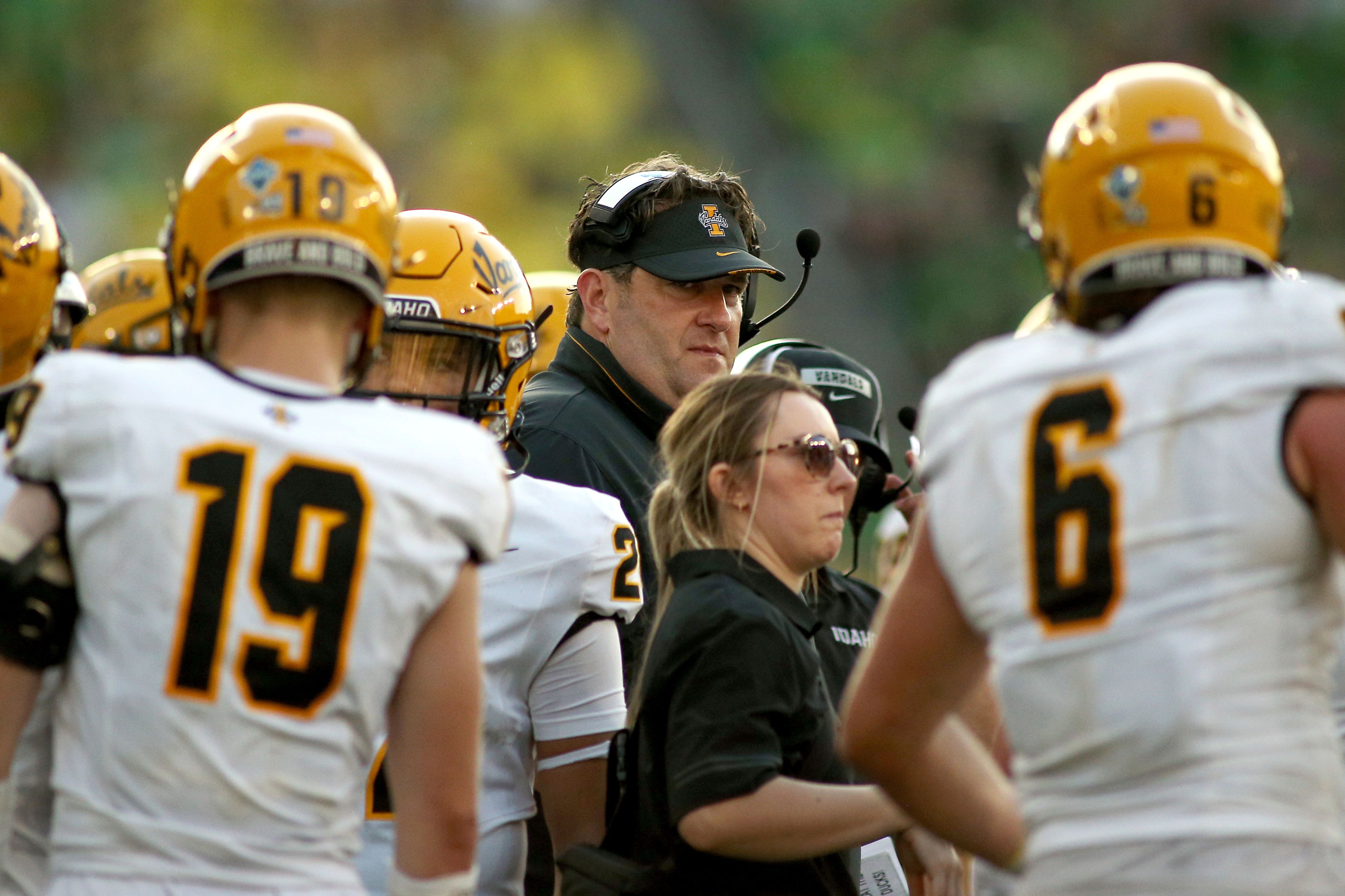 Idaho head coach Jason Eck, center, groups up with his players during the second half of an NCAA college football game against Oregon, Saturday, Aug. 31, 2024, in Eugene, Ore. (AP Photo/Lydia Ely)