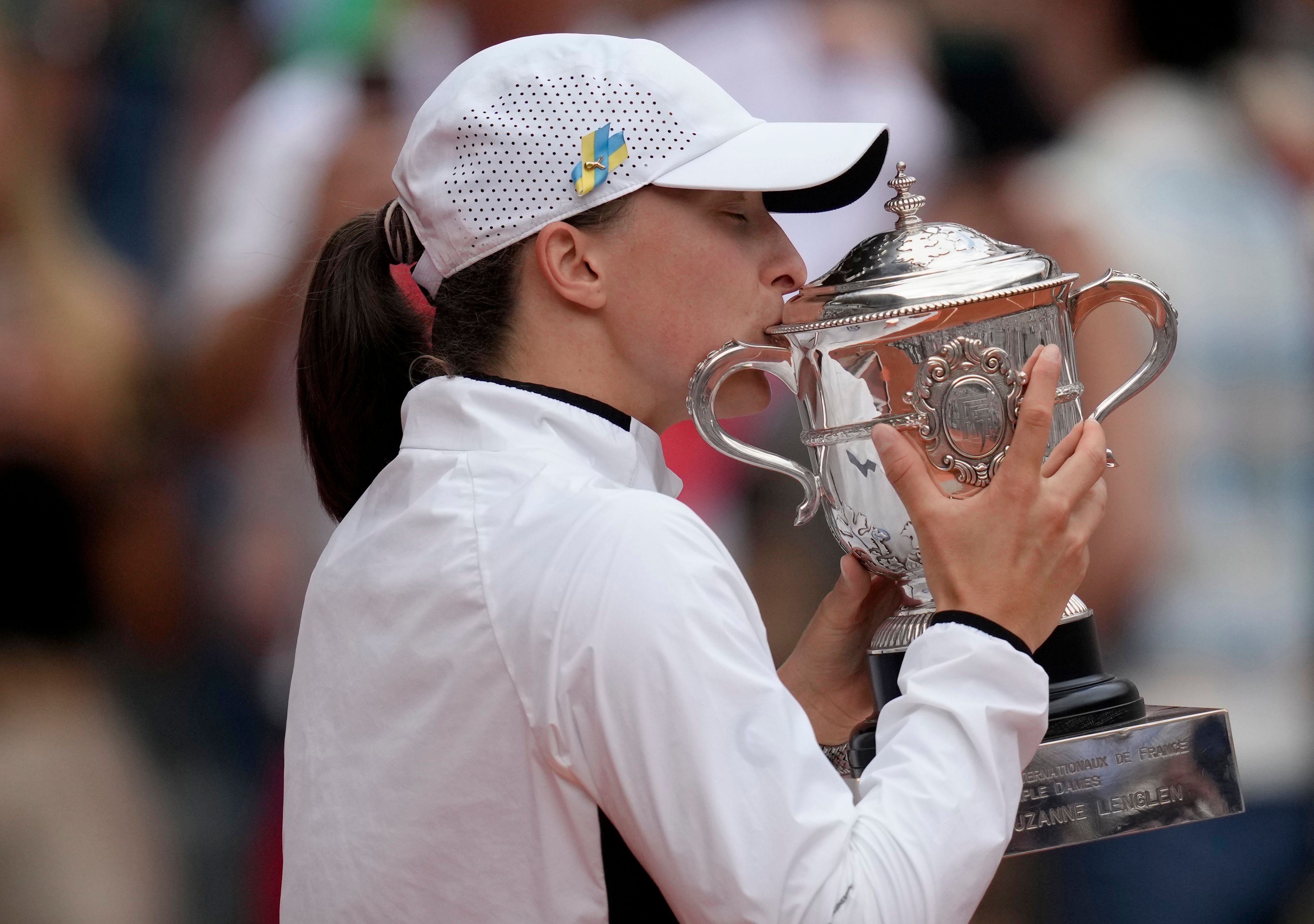 FILE - Poland's Iga Swiatek kisses the trophy as she celebrates winning the women's final match of the French Open tennis tournament against Karolina Muchova of the Czech Republic in three sets, 6-2, 5-7, 6-4, at the Roland Garros stadium in Paris, Saturday, June 10, 2023. Swiatek has been No. 1 in the WTA rankings for most of the past two years and will seek her fourth championship at Roland Garros — and fifth Grand Slam trophy overall — when play begins at the clay-court major tournament Sunday.