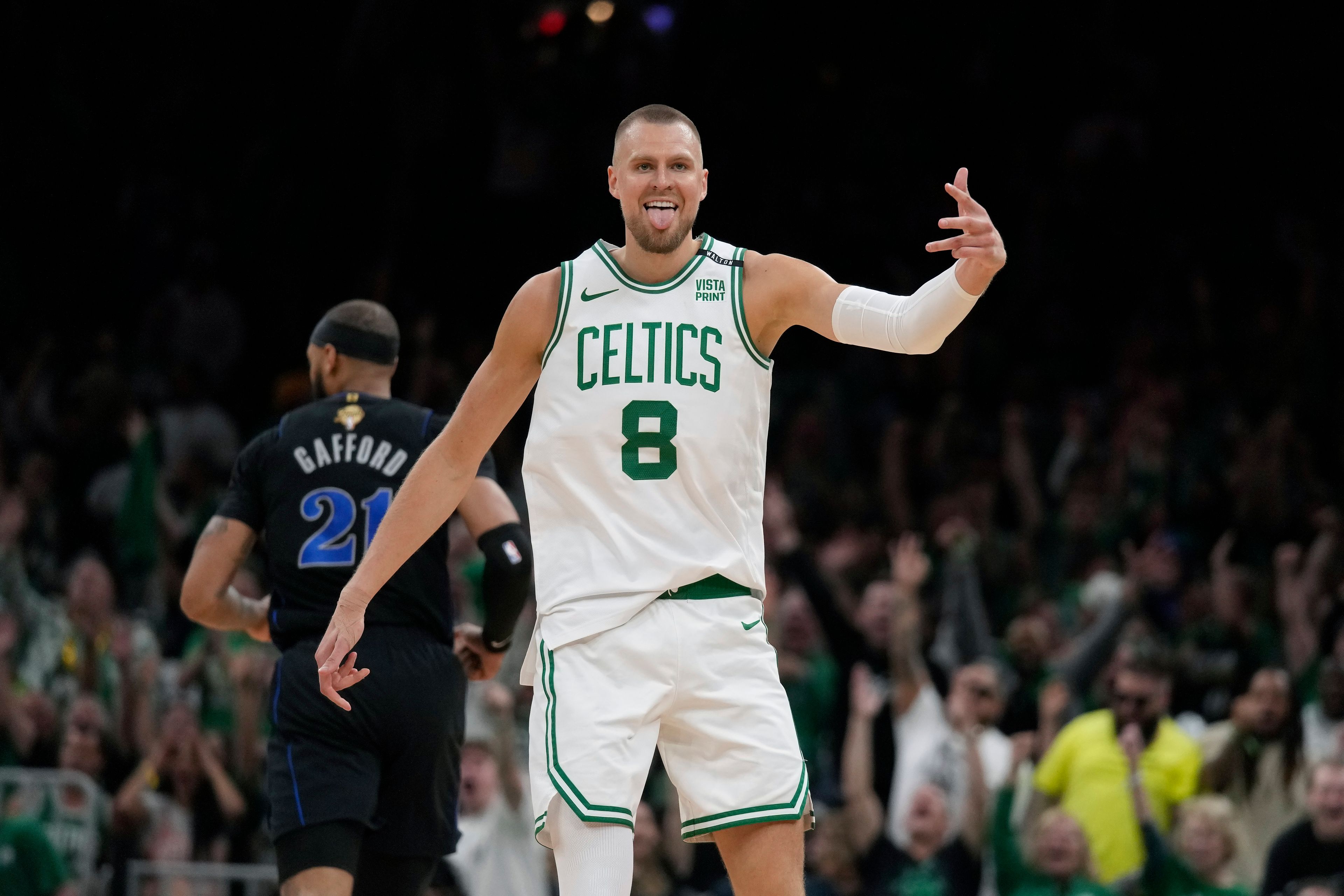 Boston Celtics center Kristaps Porzingis (8) celebrates a 3-pointer, near Dallas Mavericks center Daniel Gafford (21) during the first half of Game 1 of basketball's NBA Finals on Thursday, June 6, 2024, in Boston.