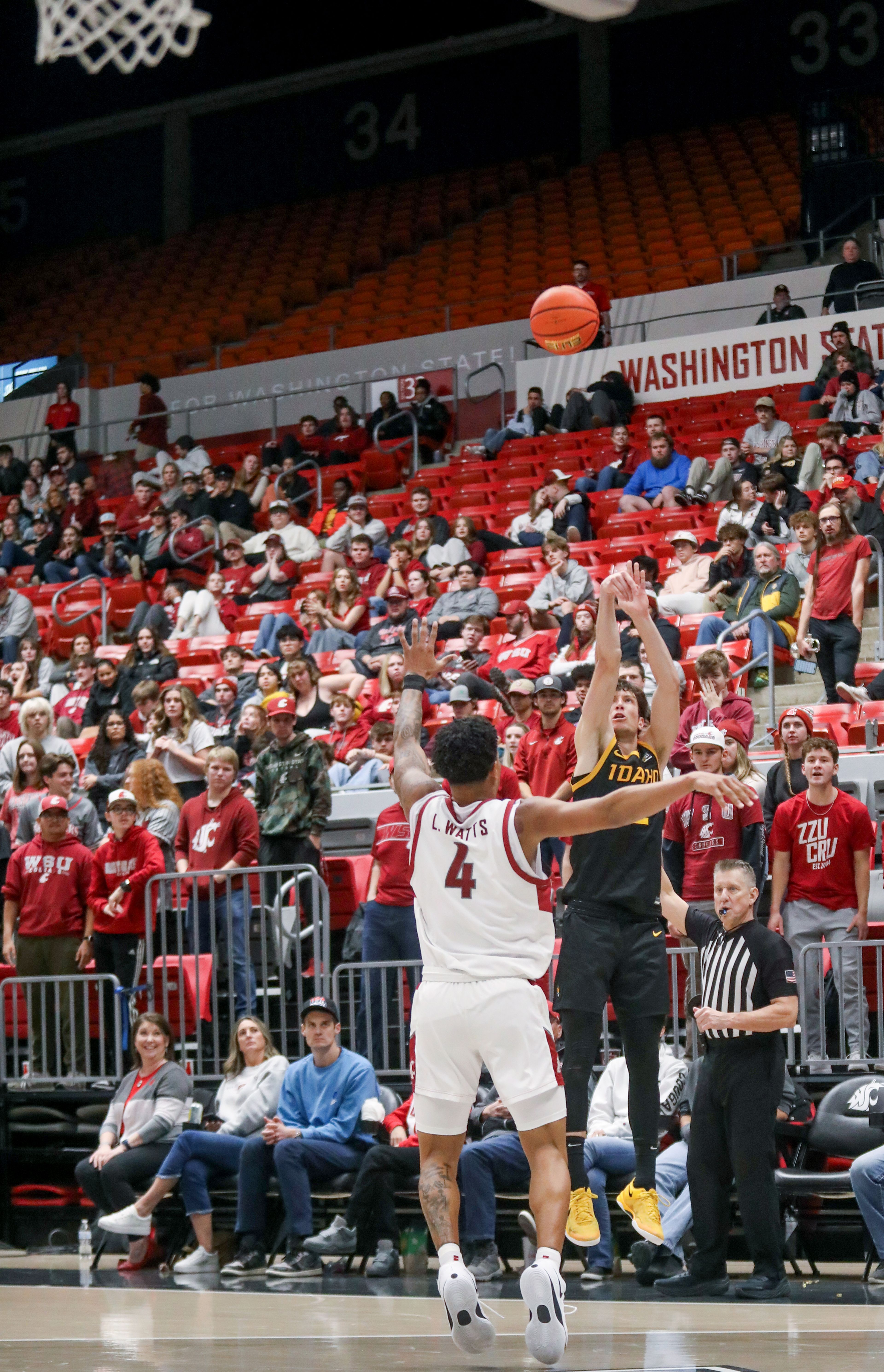 Idaho forward Tyler Mrus attempts a three-point shot with pressure from Washington State forward LeJuan Watts during the Battle of the Palouse game Monday at Beasley Coliseum in Pullman.