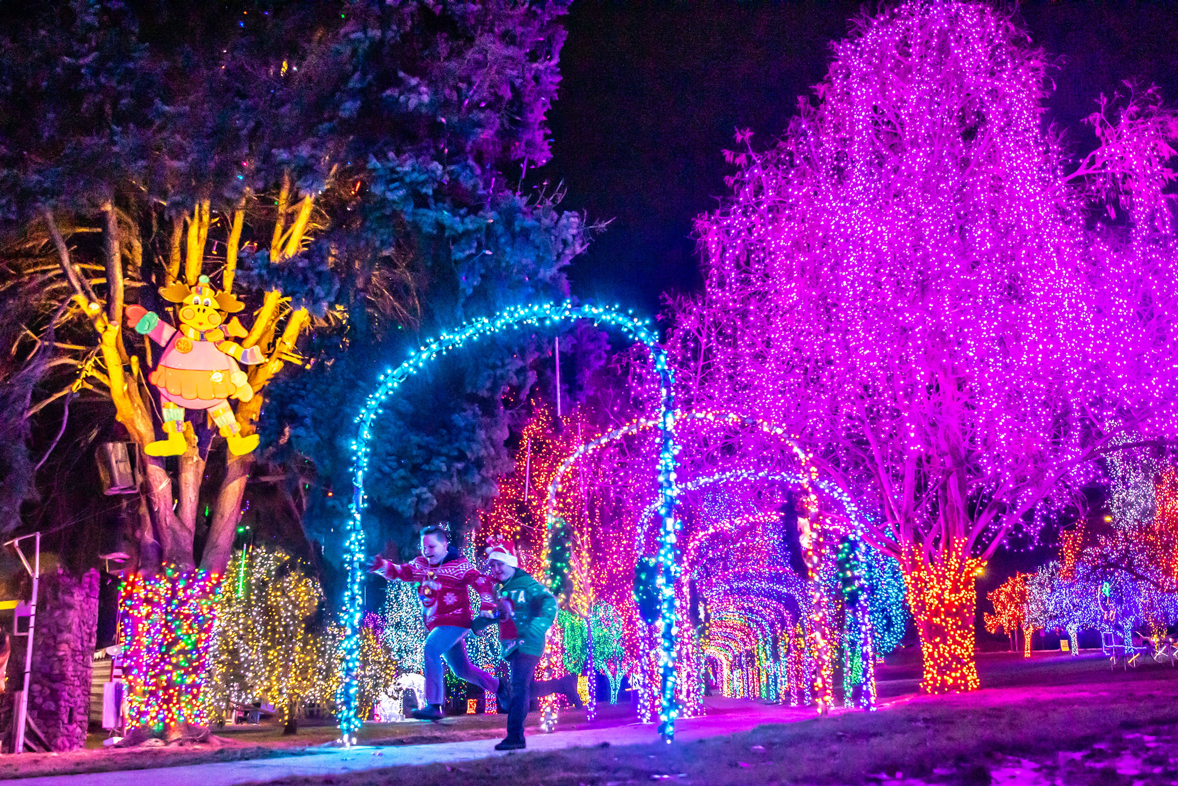 Kids race through the tunnel at the Winter Spirit holiday light display Wednesday at Locomotive Park in Lewiston.