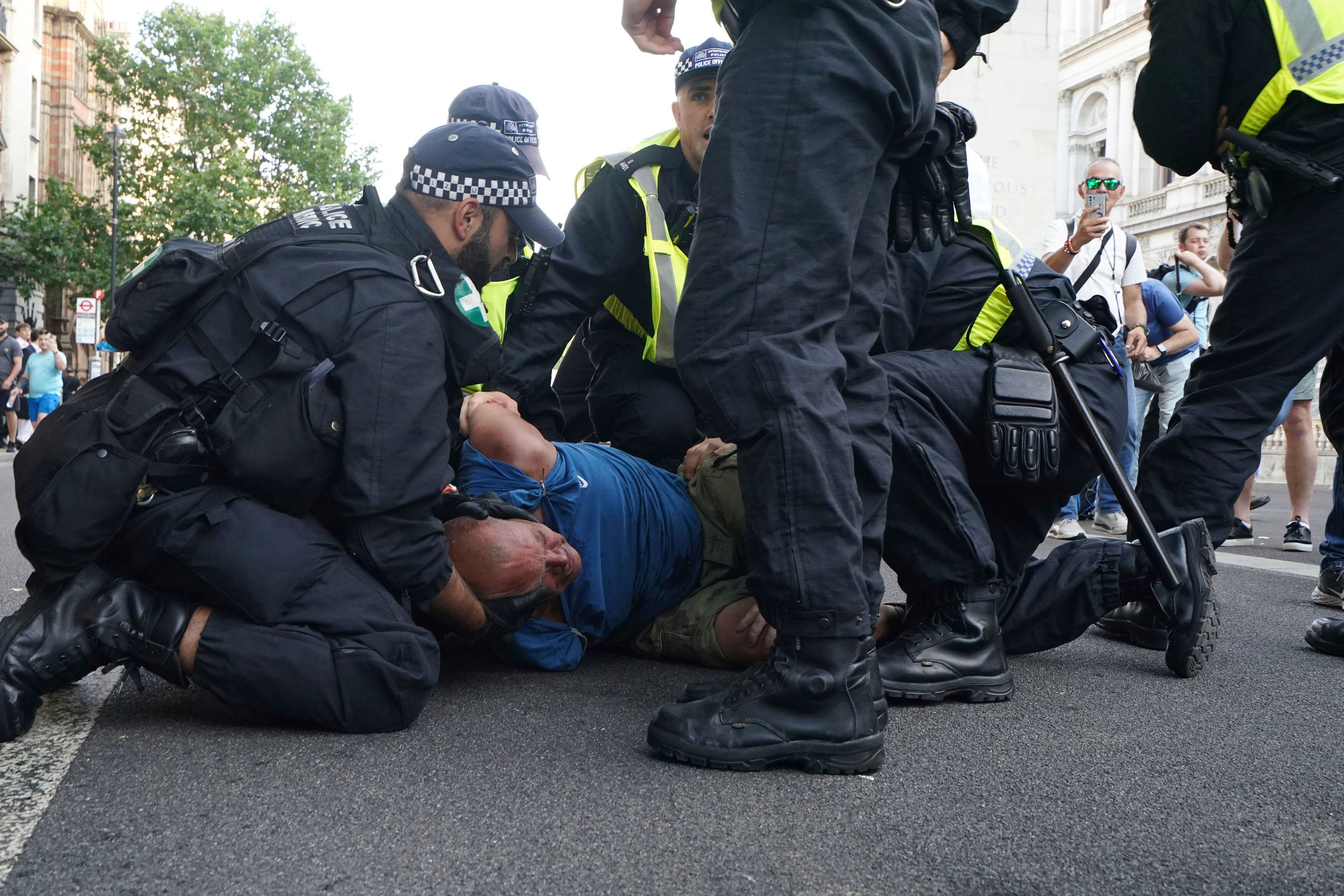 A protester is detained by the police during a 'Enough is Enough' protest rally in Whitehall, London, Wednesday July 31, 2024 following the fatal stabbing of three children at a Taylor Swift-themed holiday club on Monday in Southport. (Jordan Pettitt/PA via AP)