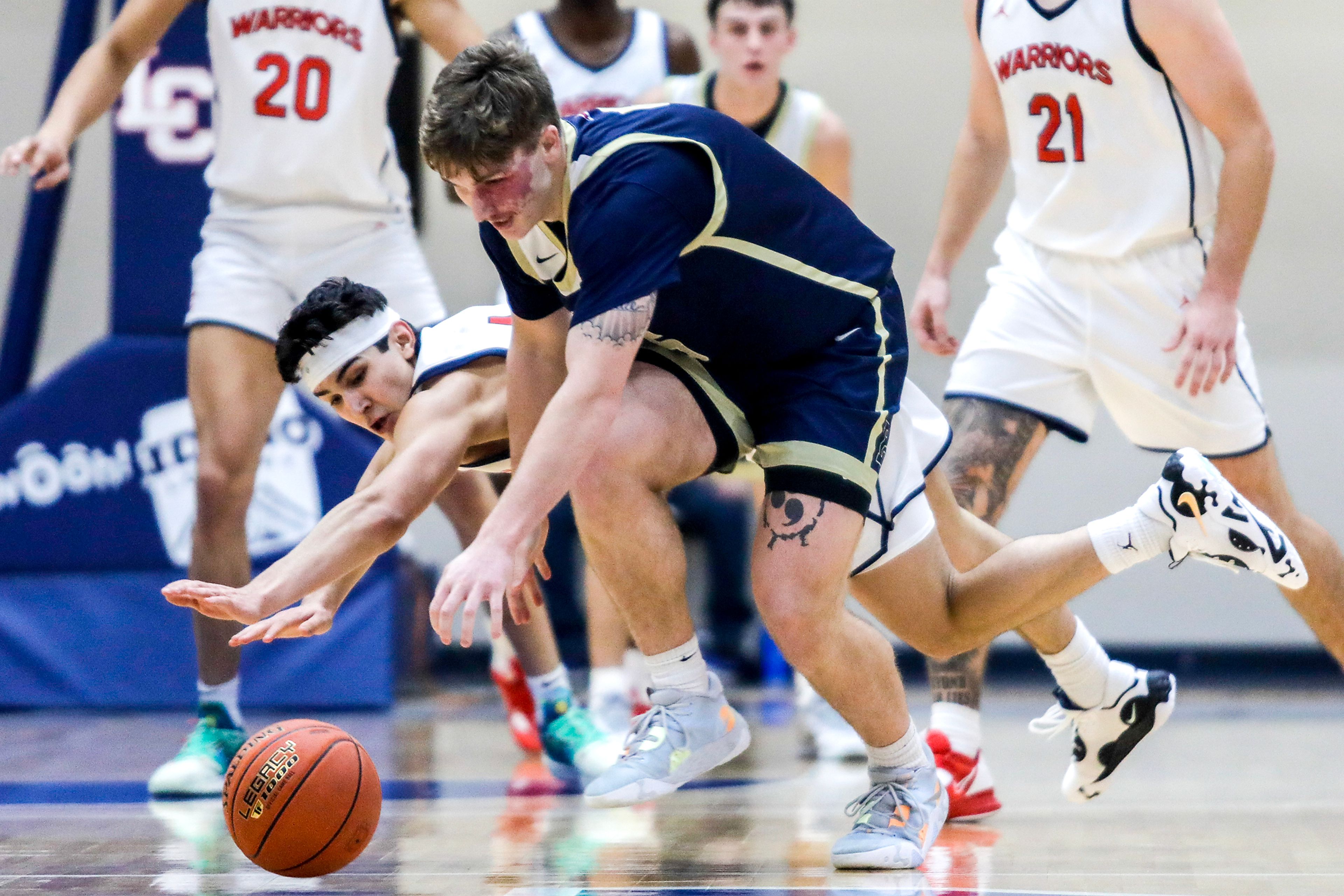 Lewis-Clark State guard Silas Bennion dives after a loose ball that was reclaimed by Eastern Oregon forward Preston Chandler, front, during a Cascade Conference game Friday at Lewis-Clark State College.