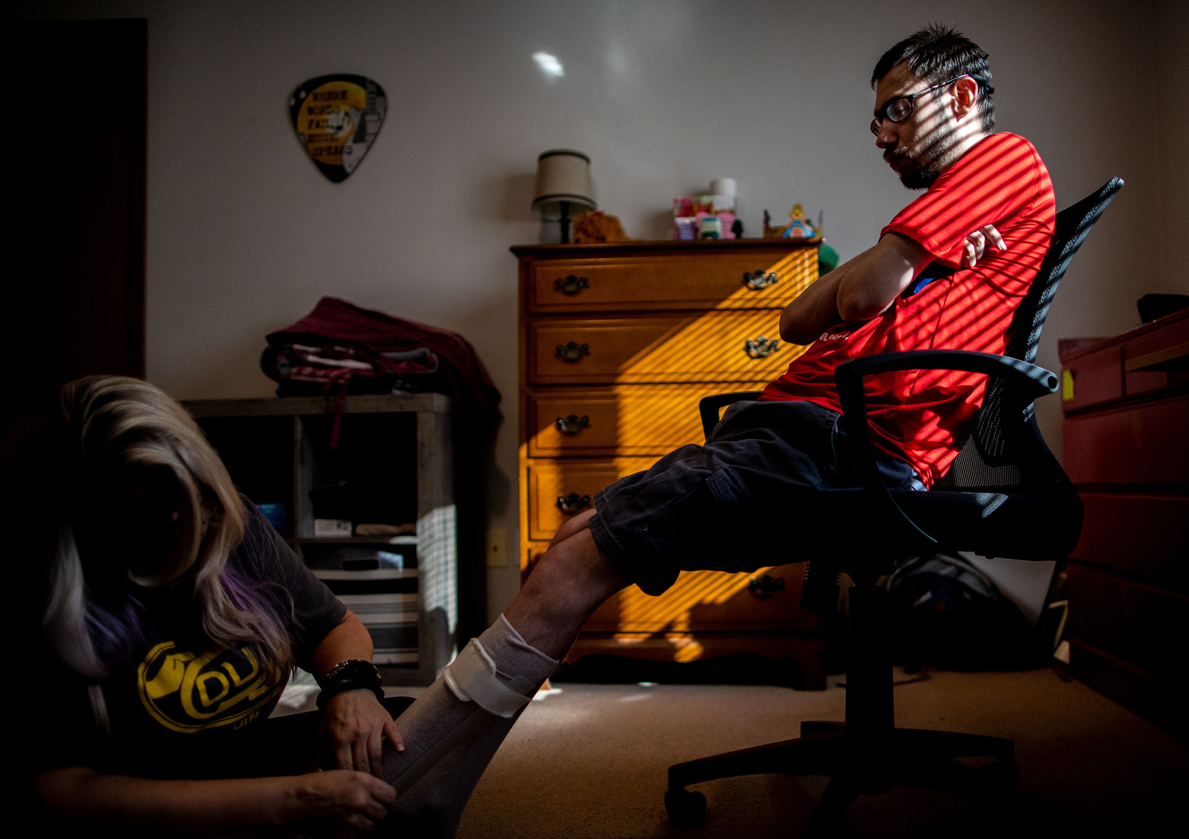 Opportunities Unlimited Inc. client Kees Beehner, right, gets some helping putting on his shoes from 24-Hour House Lead Jill Grant before Beehner heads off to participate in an OUI group activity on Sept. 21.