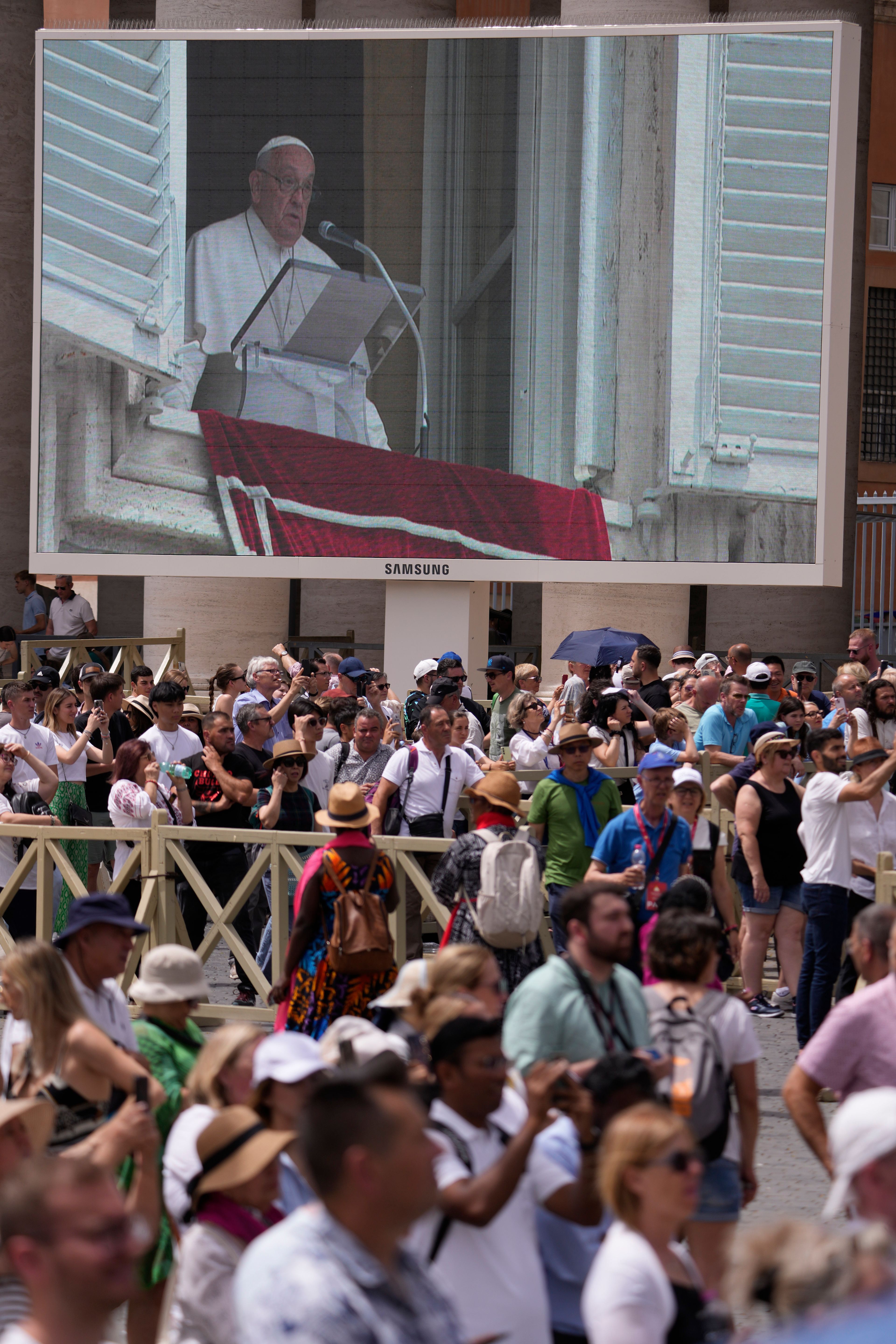 Pope Francis appears on a giant monitor in St. Peter's Square at The Vatican as he appears at his studiio's window overlooking the square, Sunday, June 9, 2024, where faithful and pilgrims gathered for the traditional Sunday's blessing at the end of the Angelus prayer.