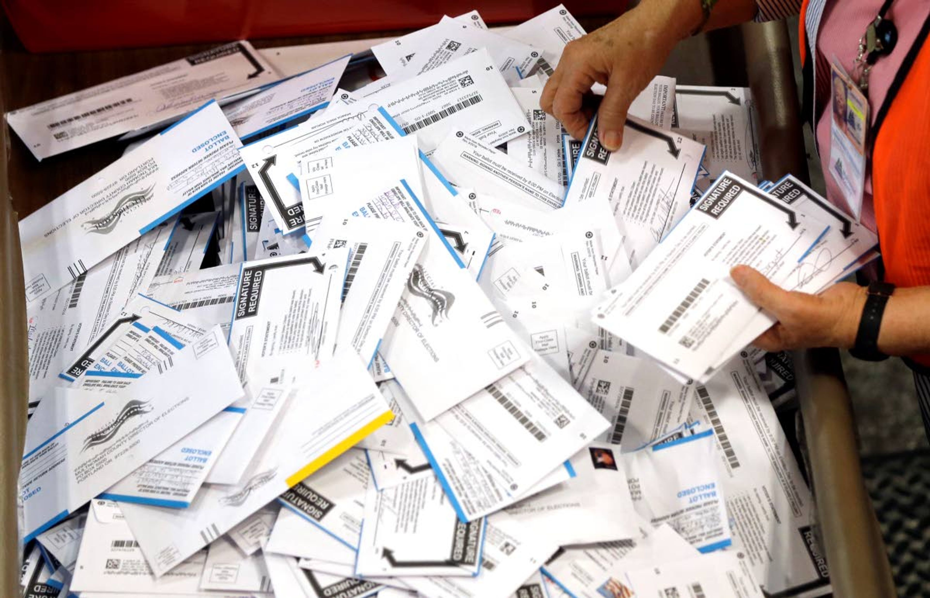 FILE - In this May 17, 2016, file photo, ballots are prepared for counting at Multnomah County election headquarters in Portland, Ore. Oregon's elections director says the voting system in the state has never been more accurate or secure, though the number of phishing attempts targeting elections officials has increased here and elsewhere. (AP Photo/Don Ryan, File)