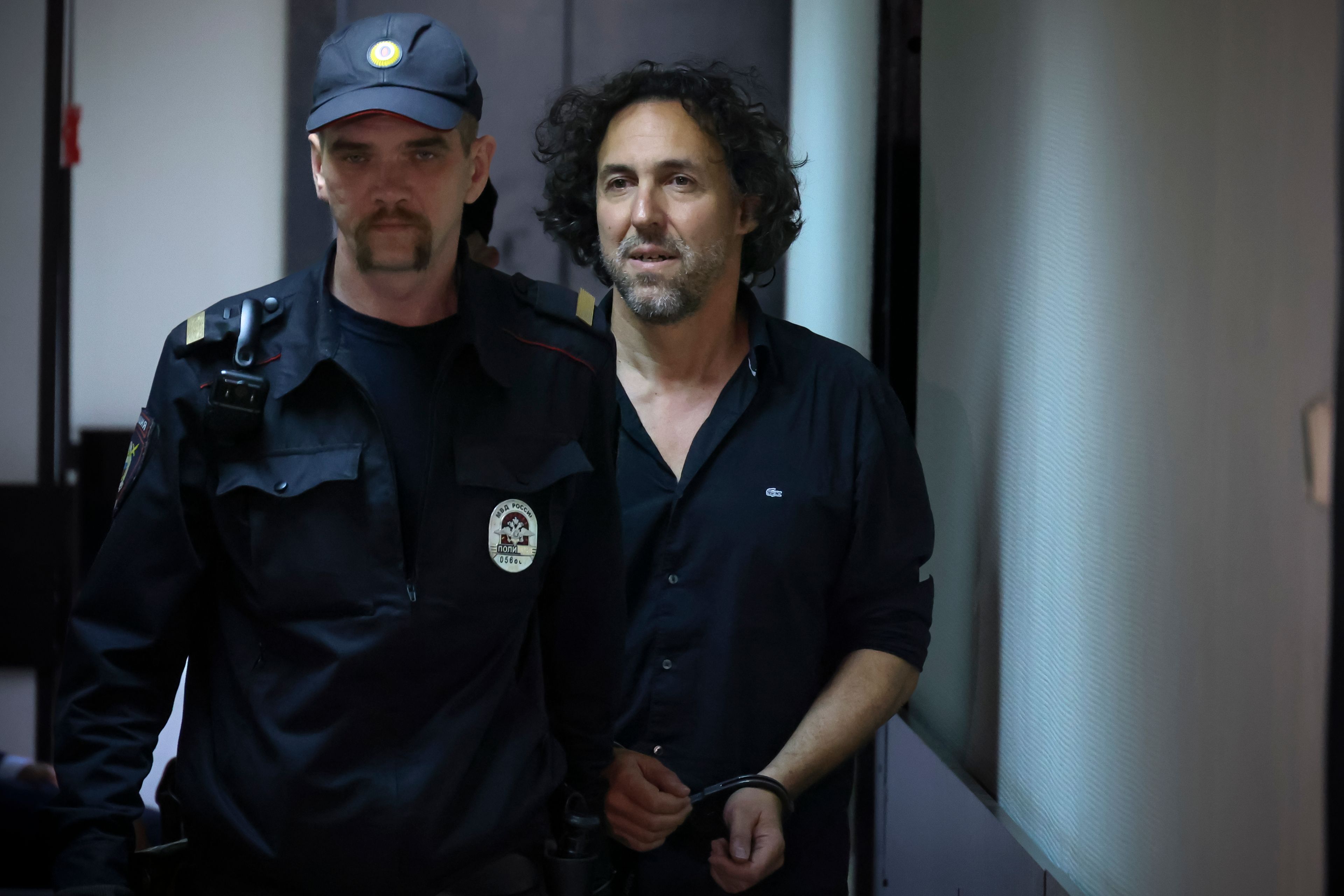 French citizen Laurent Vinatier, right, is escorted into a cage in a courtroom in the Zamoskvoretsky District Court in Moscow, Russia on Friday, June 7, 2024. A court in Moscow has ordered that the French citizen accused of collecting information on military issues in Russia be held in pre-trial custody. Vinatier was arrested in the Russian capital on Thursday as tensions have flared between Moscow and Paris following French President Emmanuel Macron’s statements about the possibility of deploying the country’s troops in Ukraine.