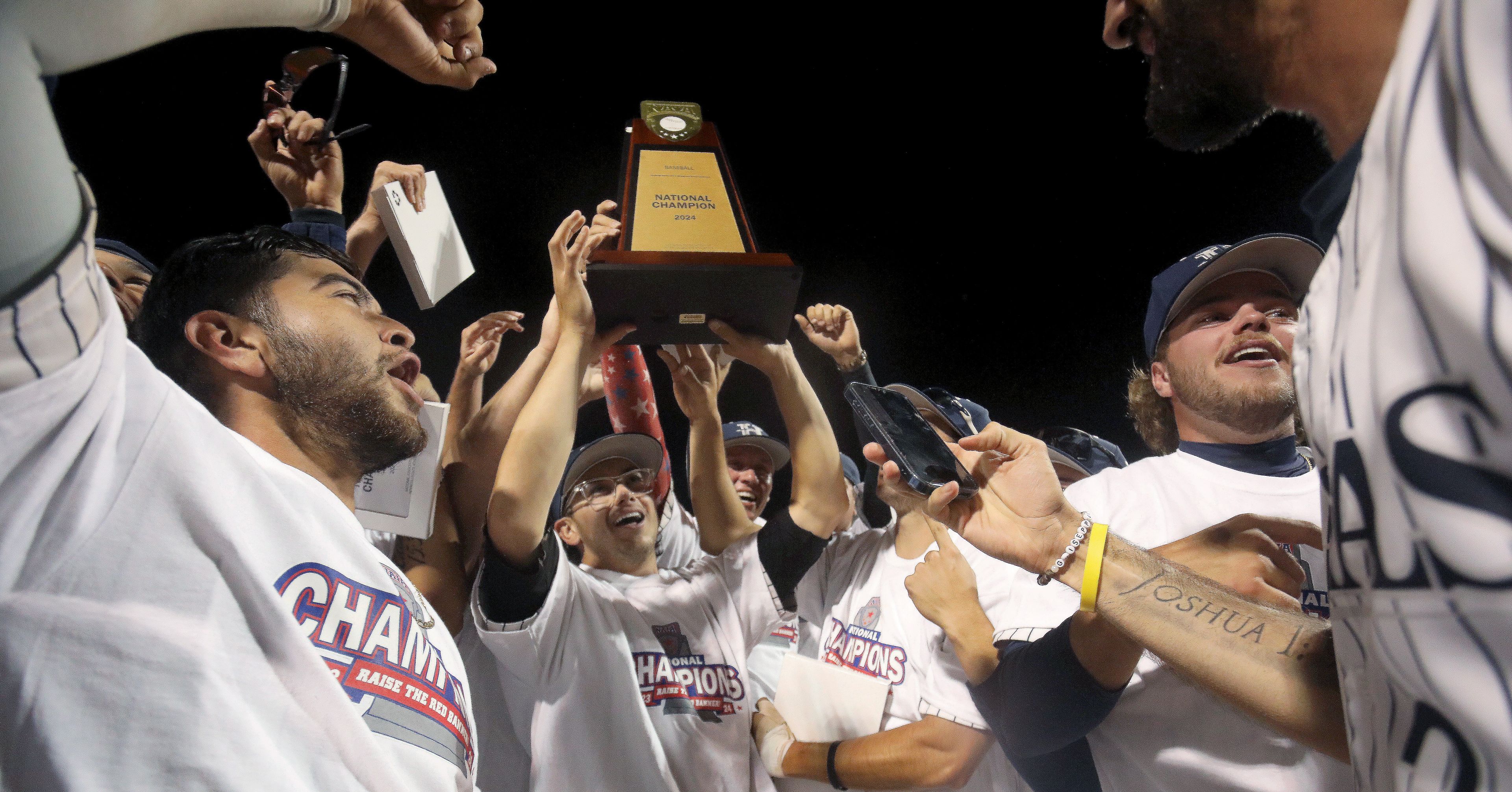 Hope International raises the national champion trophy after beating Tennessee Wesleyan in the championship game of the NAIA World Series at Harris Field in Lewiston on Friday.