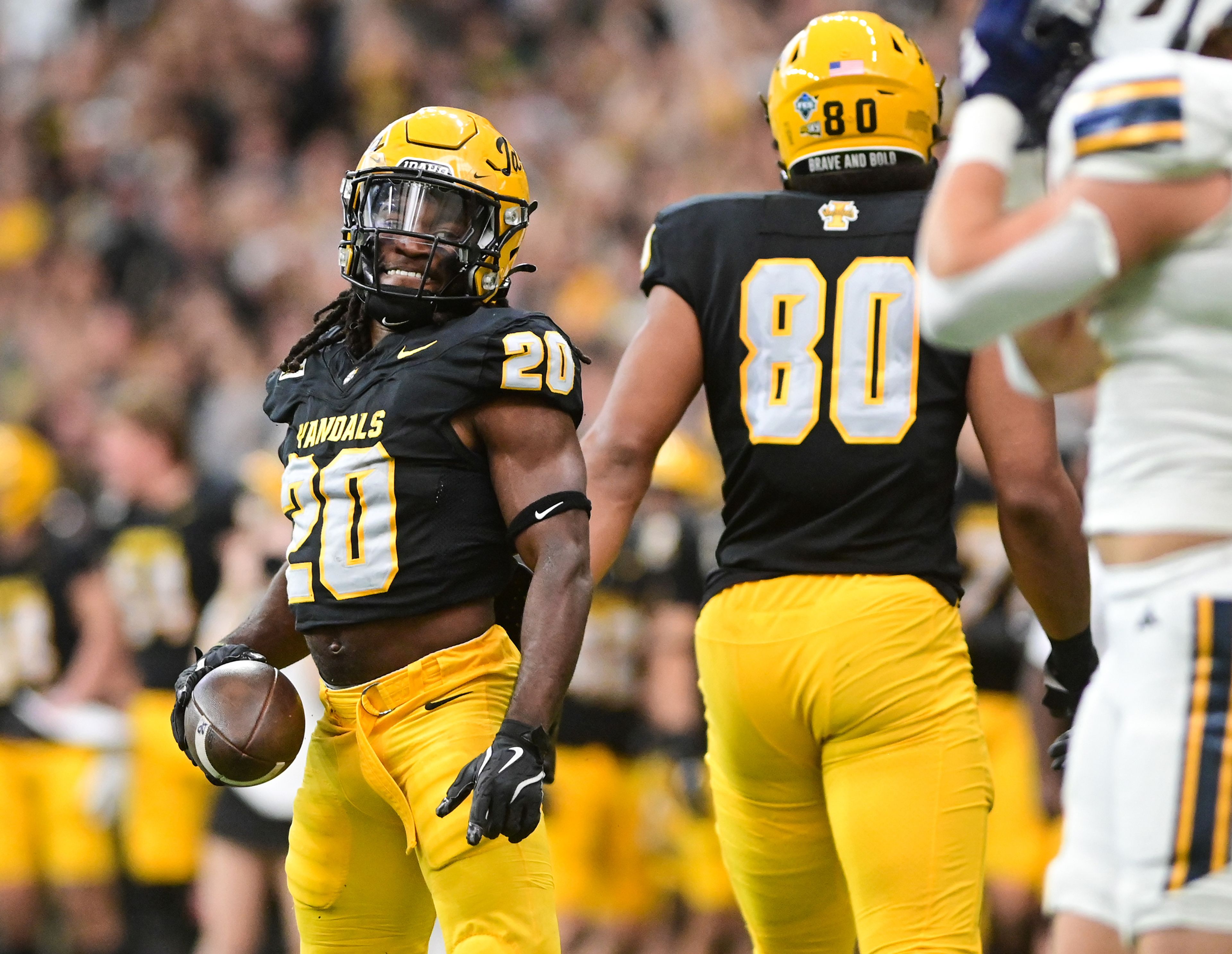 Idaho running back Elisha Cummings celebrates carrying the ball downfield in a break-away play against Northern Arizona on Saturday at the P1FCU Kibbie Dome in Moscow.,